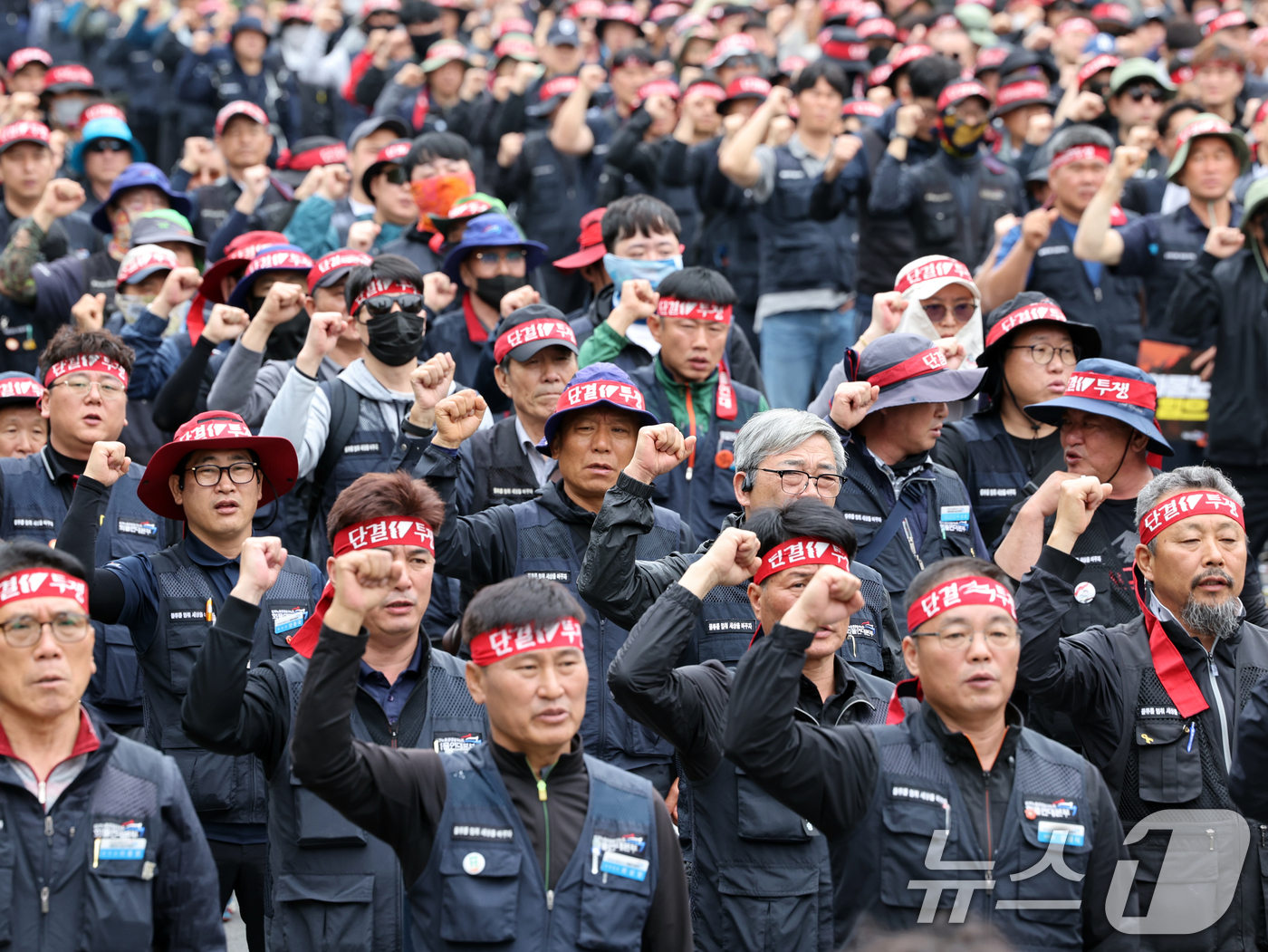 (서울=뉴스1) 황기선 기자 = 민주노총 화물연대본부 조합원들이 19일 오후 서울 영등포구 여의도 국회의사당역 앞에서 열린 '확대간부 결의대회'에서 민중의례를 하고 있다. 2025 …