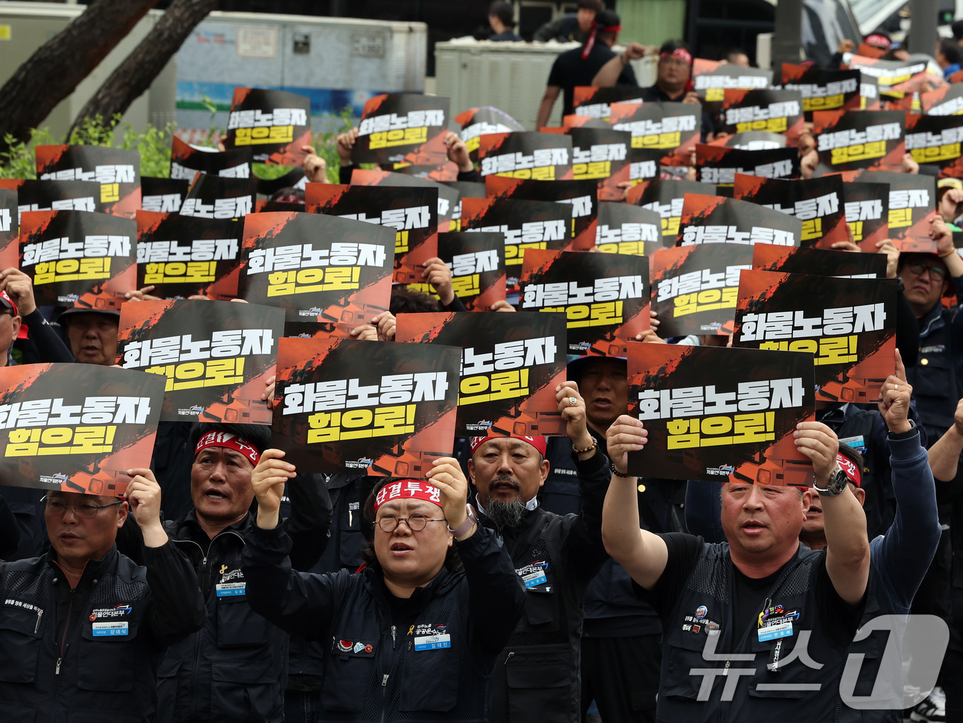 (서울=뉴스1) 황기선 기자 = 민주노총 화물연대본부 조합원들이 19일 오후 서울 영등포구 여의도 국회의사당역 앞에서 열린 '확대간부 결의대회'에서 구호를 외치고 있다. 2025. …