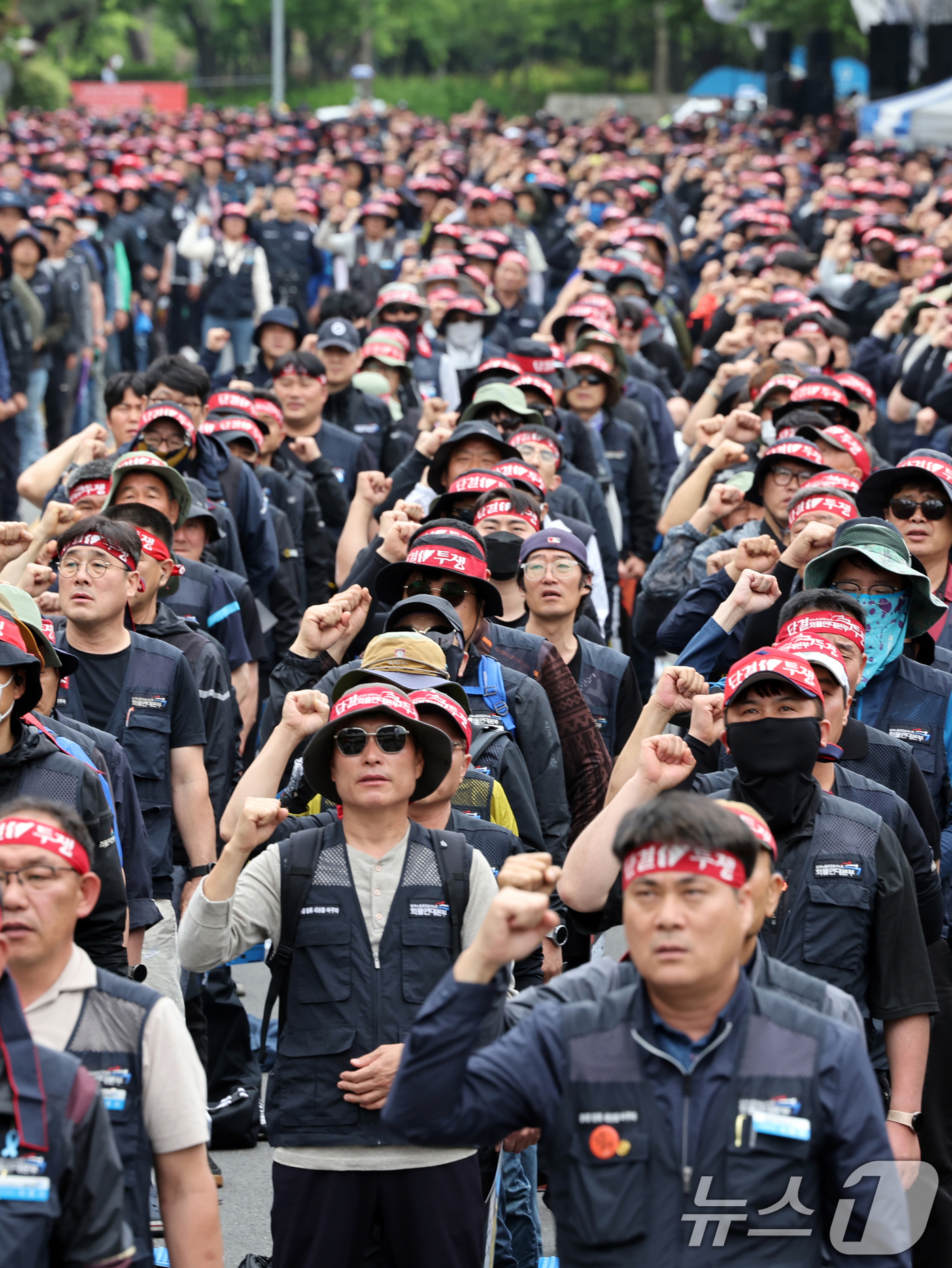 (서울=뉴스1) 황기선 기자 = 민주노총 화물연대본부 조합원들이 19일 오후 서울 영등포구 여의도 국회의사당역 앞에서 열린 '확대간부 결의대회'에서 민중의례를 하고 있다. 2025 …