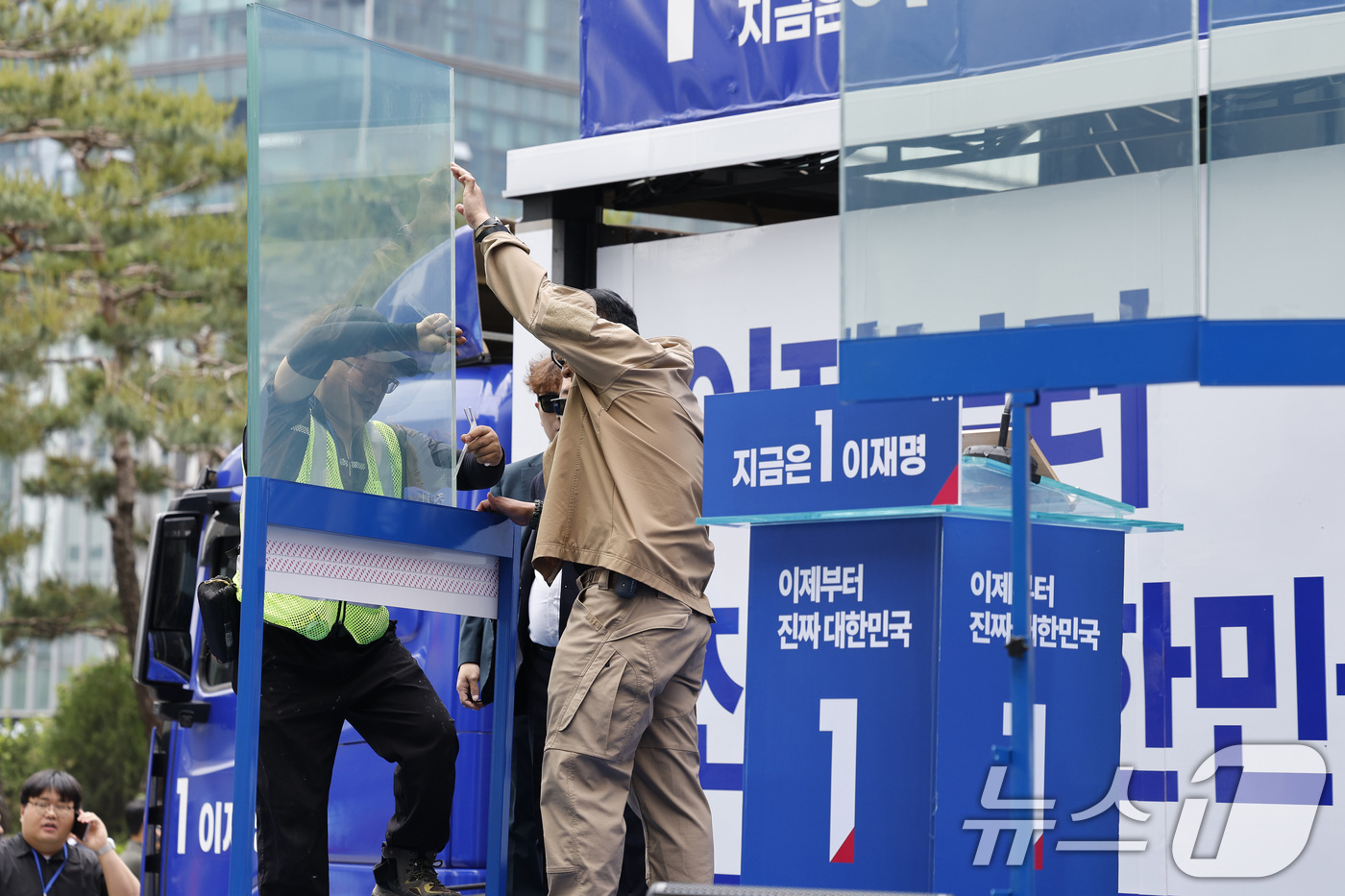 (서울=뉴스1) 안은나 기자 = 19일 오후 서울 용산역 광장에서 이재명 더불어민주당 대통령 후보의 집중유세가 예정된 가운데 관계자들이 만일의 사태를 대비해 방탄유리막을 설치하고 …