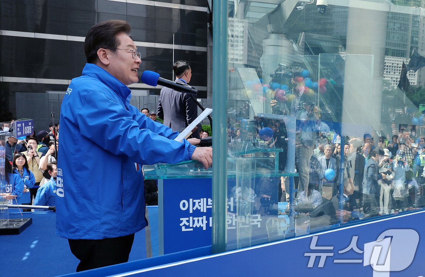 본문 이미지 - 이재명 더불어민주당 대통령 후보가 19일 오후 서울 용산역 광장에 마련된 &#39;방탄 유리&#39; 연단에서 유권자들을 향해 지지를 호소하고 있다. 2025.5.19/뉴스1 ⓒ News1 안은나 기자