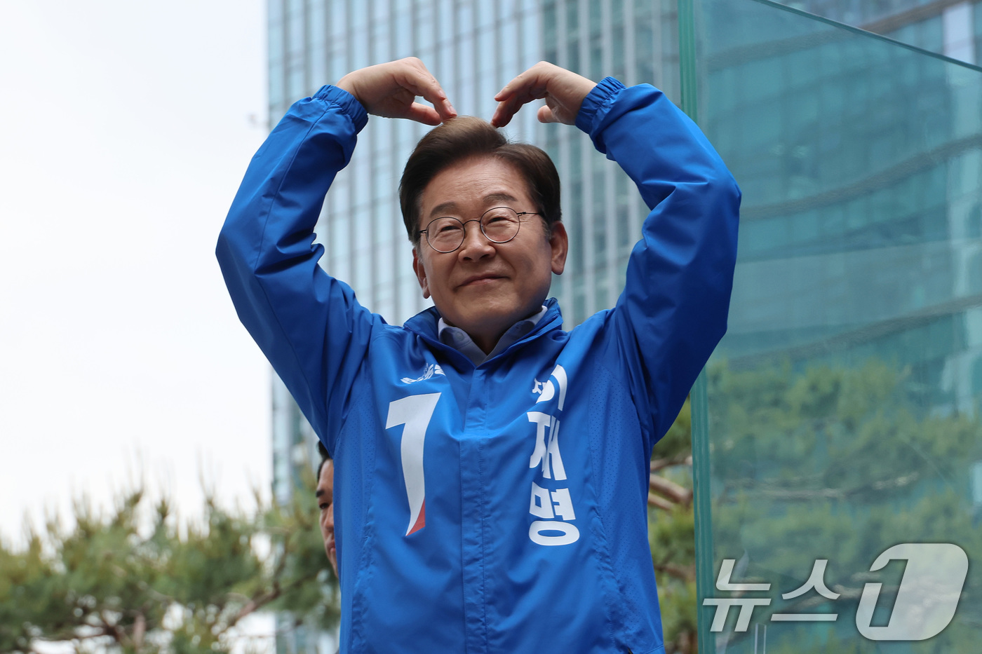 (서울=뉴스1) 안은나 기자 = 이재명 더불어민주당 대통령 후보가 19일 서울 용산역광장에서 열린 집중유세에서 방탄유리가 설치된 유세차 위에서 유권자들을 향해 지지를 호소하며 하트 …