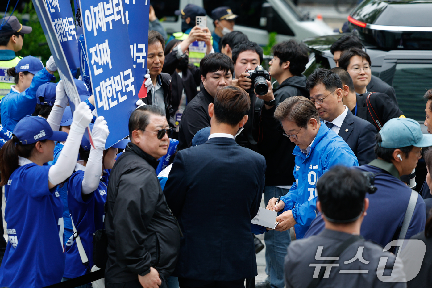 (서울=뉴스1) 안은나 기자 = 이재명 더불어민주당 대통령 후보가 19일 오후 서울 영등포구 타임스퀘어에서 유세를 마친 뒤 책에 사인해주고 있다. 2025.5.19/뉴스1