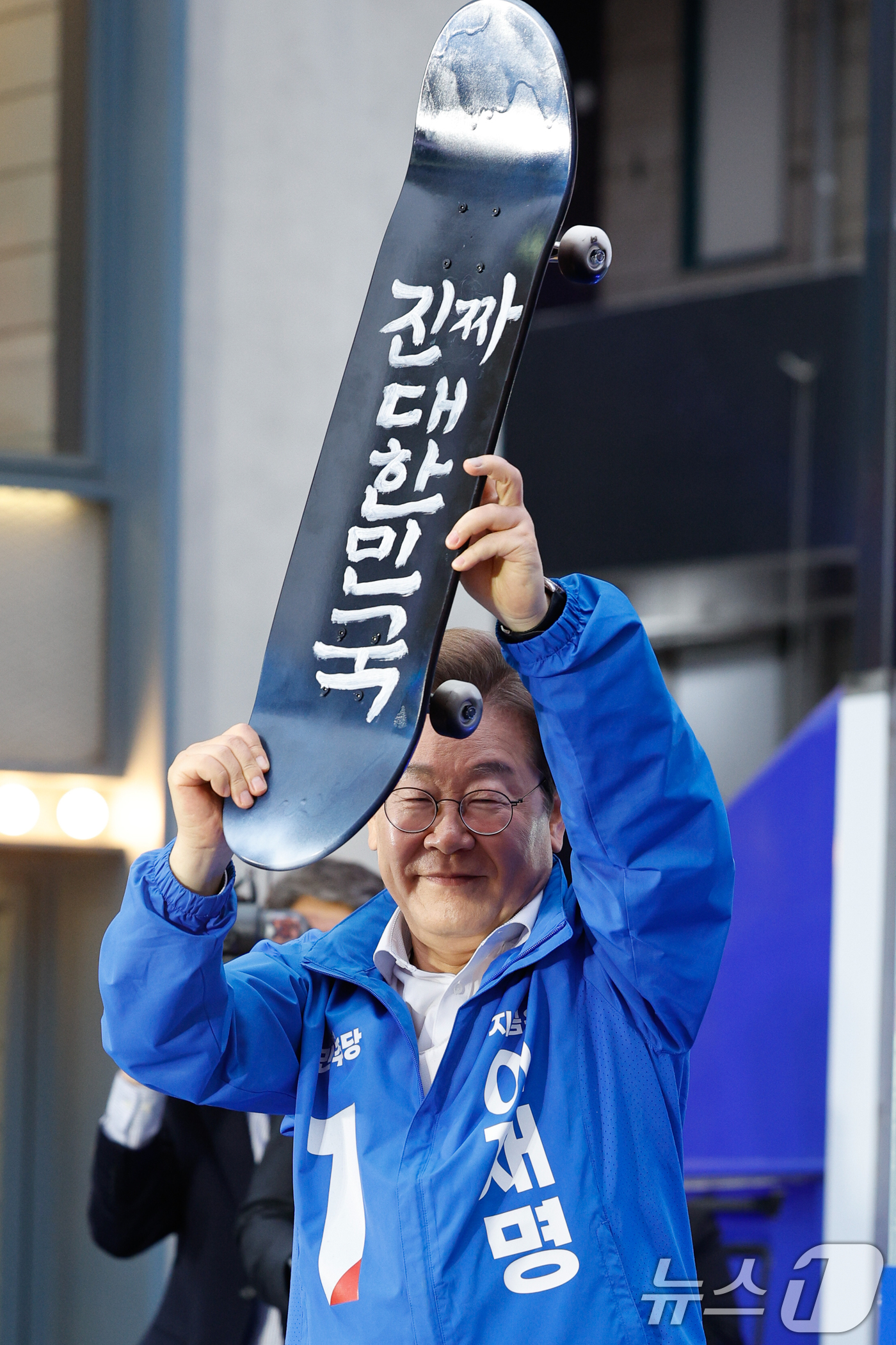 (서울=뉴스1) 안은나 기자 = 이재명 더불어민주당 대통령 후보가 19일 오후 서울 마포구 홍대 레드로드를 찾아 유세에 앞서 '진짜 대한민국'이라고 적힌 스케이트 보드를 들어 보이 …