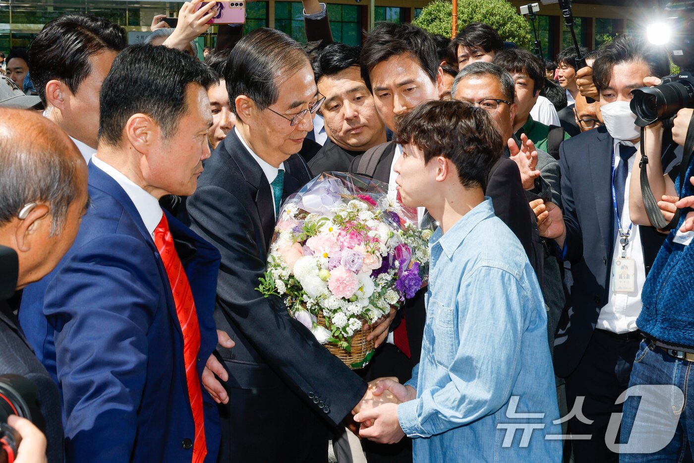 본문 이미지 - 한덕수 전 국무총리가 2일 오전 서울 여의도 국회 소통관에서 &#39;국민께 드리는 약속&#39;을 주제로 제21대 대통령 선거 출마를 선언한 뒤 지지자로부터 꽃바구니를 받고 있다. 2025.5.2/뉴스1 ⓒ News1 안은나 기자