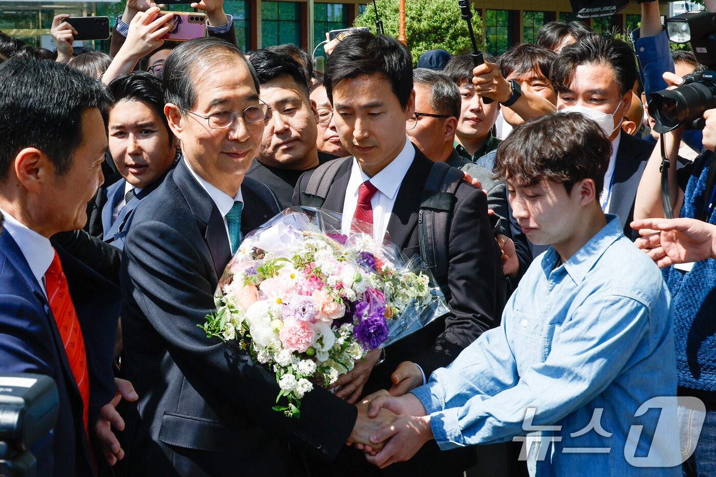 본문 이미지 - 한덕수 전 국무총리가 2일 오전 서울 여의도 국회 소통관에서 &#39;국민께 드리는 약속&#39;을 주제로 제21대 대통령 선거 출마를 선언한 뒤 지지자로부터 꽃바구니를 받고 있다. 2025.5.2/뉴스1 ⓒ News1 안은나 기자