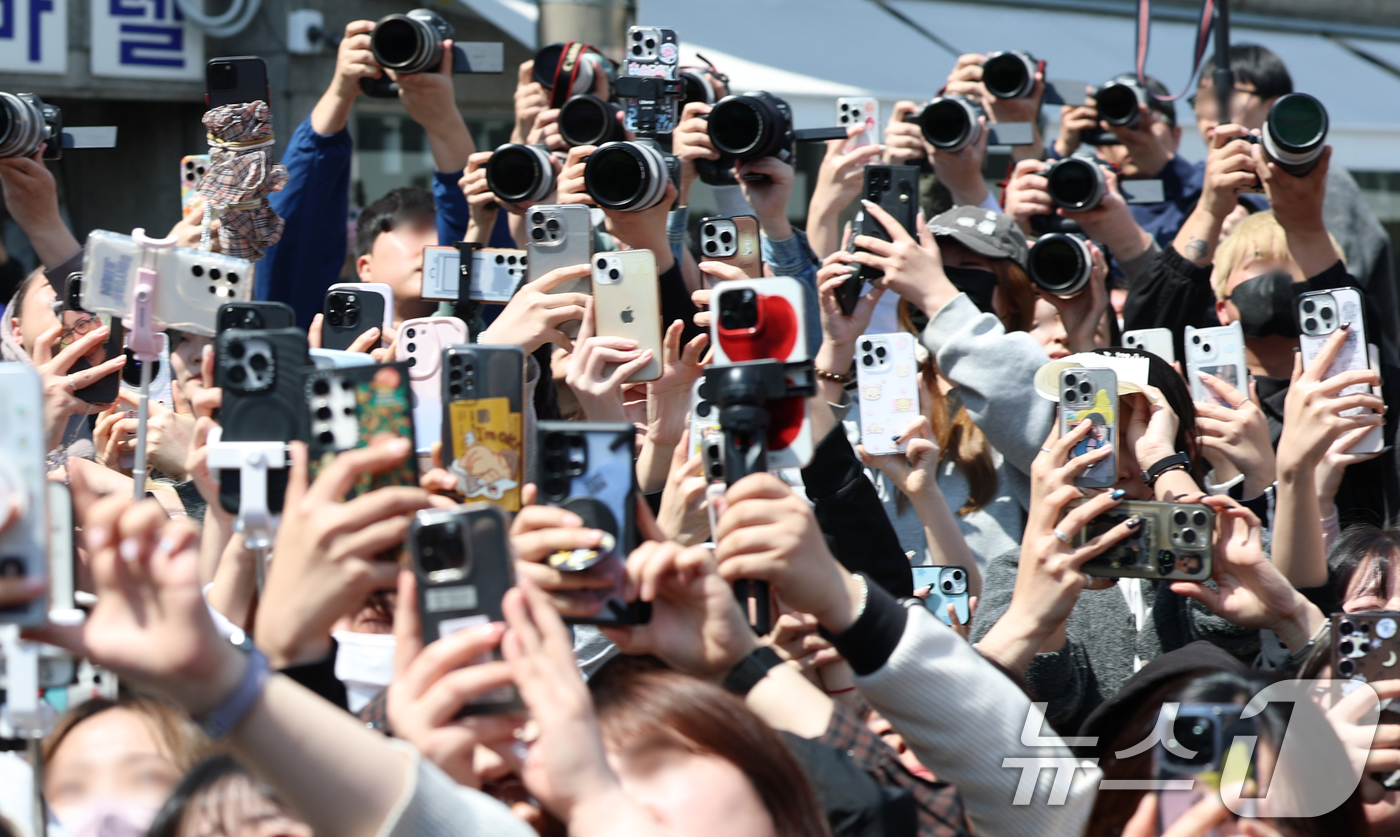 (서울=뉴스1) 권현진 기자 = 세븐틴 팬들이 2일 오전 서울 성동구 엠엠성수 팝업 행사장에서 초코바 브랜드 '스니커즈 에너지 스테이션' 팝업 행사에 참석한 민규를 카메라를 들고 …