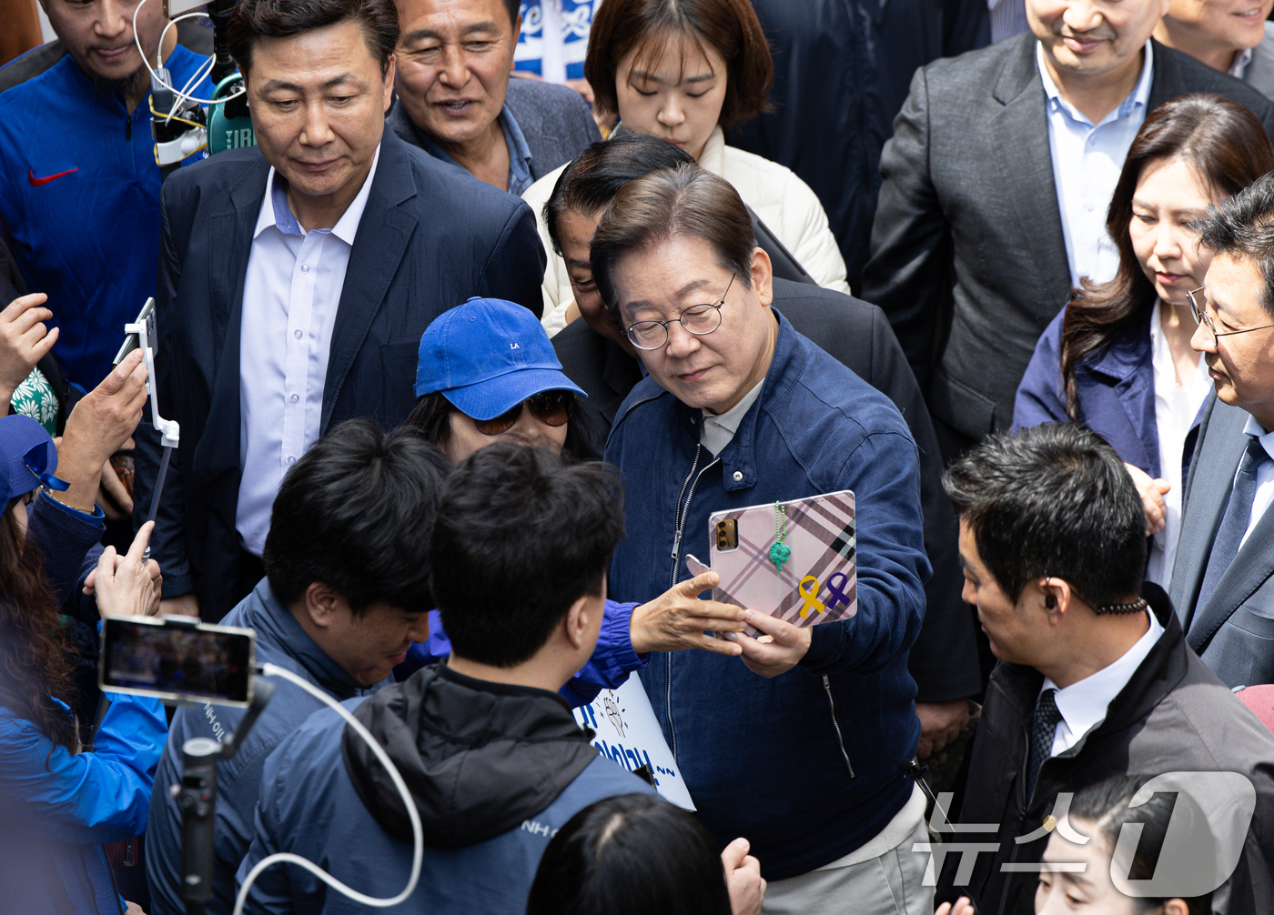 (화천=뉴스1) 이재명 기자 = '골목골목 경청투어 : 접경벨트편'에 나선 이재명 더불어민주당 대통령 후보가 2일 오후 강원 화천군 화천공영버스터미널 인근에서 지지자와 함께 기념사 …