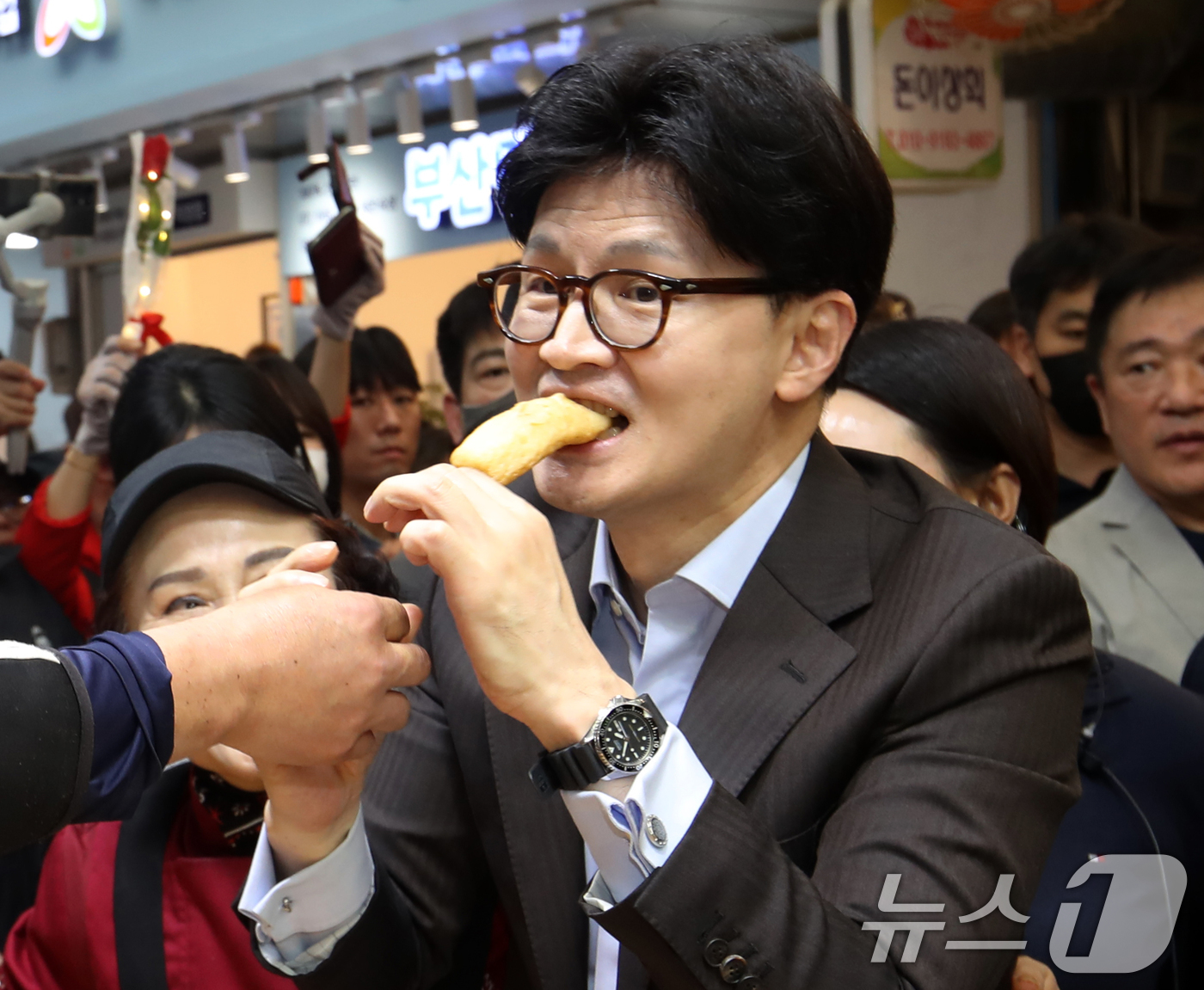 (부산=뉴스1) 윤일지 기자 = 한동훈 국민의힘 대선 경선 후보가 2일 오후 부산 중구 부평깡통시장을 상인들과 인사하며 어묵을 맛보고 있다. 2025.5.2/뉴스1