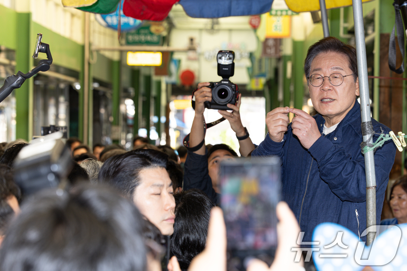 (인제=뉴스1) 이재명 기자 = '골목골목 경청투어 : 접경벨트편'에 나선 이재명 더불어민주당 대통령 후보가 2일 오후 강원 인제군 북면 원통시장에서 시민들을 향해 인사하고 있다. …