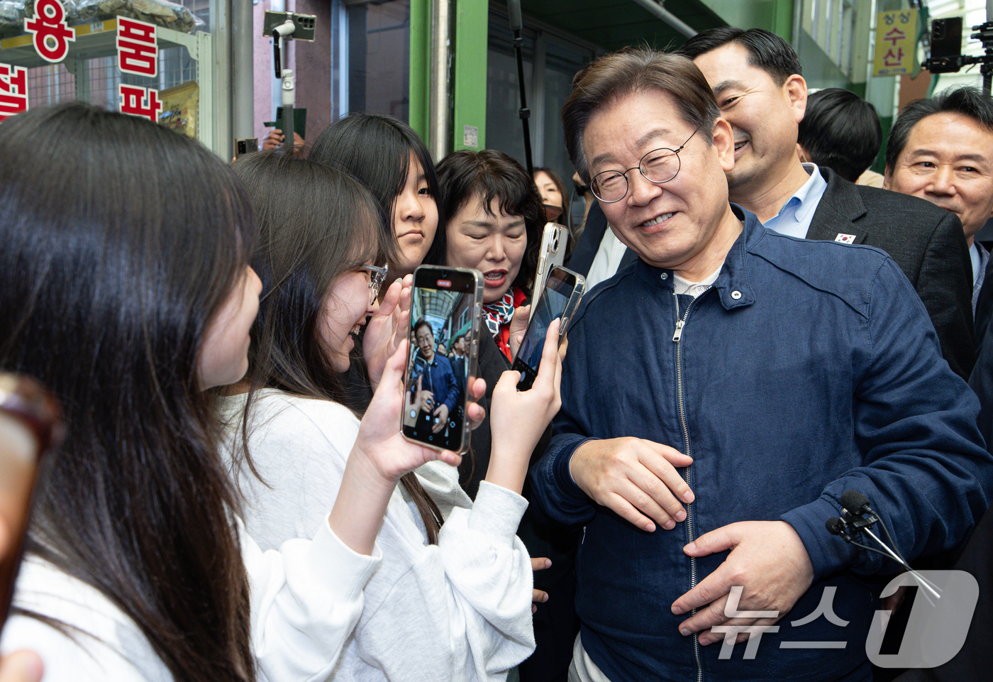 (인제=뉴스1) 이재명 기자 = '골목골목 경청투어 : 접경벨트편'에 나선 이재명 더불어민주당 대통령 후보가 2일 오후 강원 인제군 북면 원통시장에서 학생들의 사진 요청에 포즈를 …