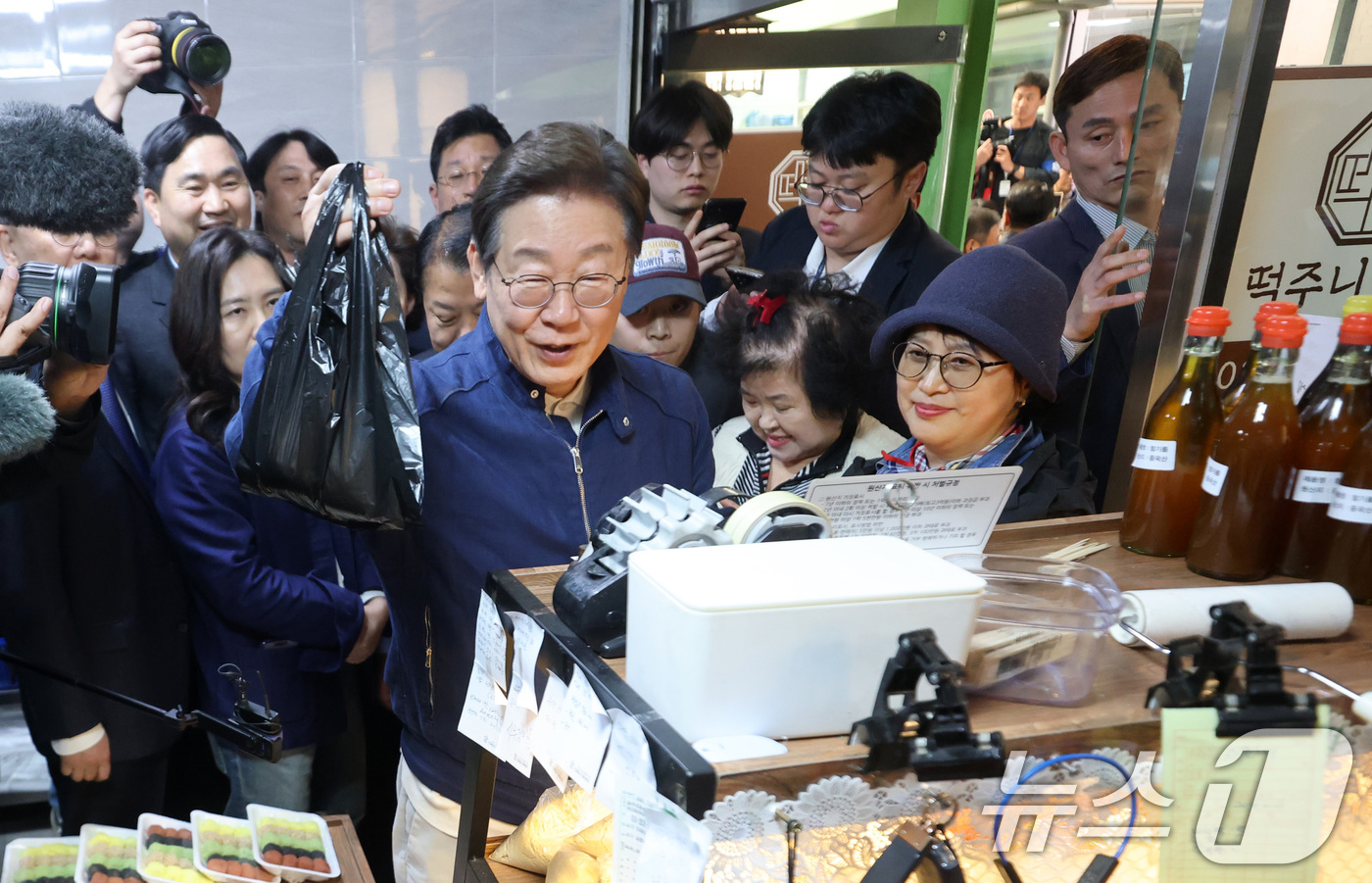 (인제=뉴스1) 이재명 기자 = '골목골목 경청투어 : 접경벨트편'에 나선 이재명 더불어민주당 대통령 후보가 2일 오후 강원 인제군 북면 원통시장에 위치한 떡집을 찾아 지역화폐로 …