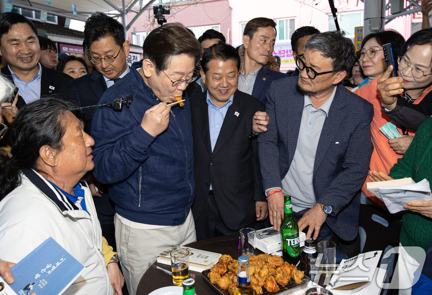 (고성=뉴스1) 이재명 기자 = '골목골목 경청투어 : 접경벨트편'에 나선 이재명 더불어민주당 대통령 후보가 2일 오후 강원 고성군 거진전통시장에서 치킨을 맛보고 있다. 2025. …