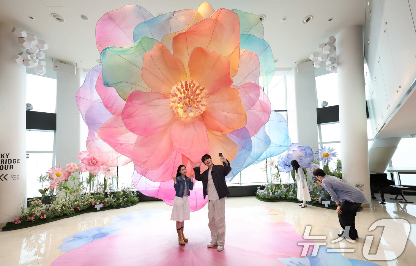 (서울=뉴스1) 박지혜 기자 = 20일 서울 송파구 롯데월드타워 전망대 서울스카이에 마련된 플라워 체험형 공간인 '블루밍 유니버스: 빅플라워' 앞에서 모델들이 포즈를 취하고 있다. …
