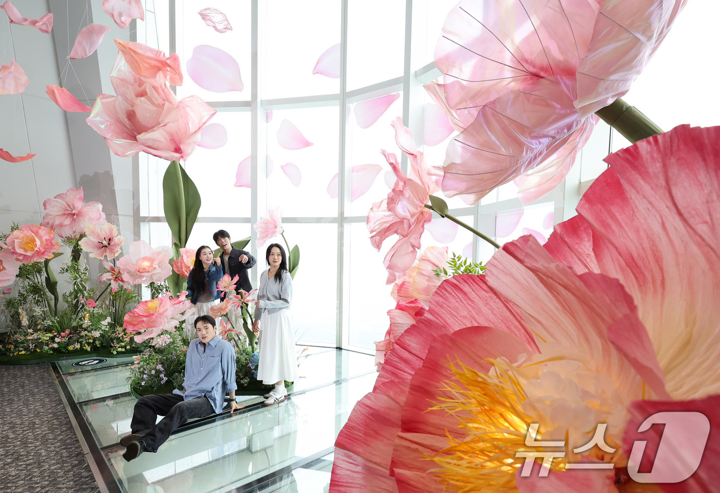 (서울=뉴스1) 박지혜 기자 = 20일 서울 송파구 롯데월드타워 전망대 서울스카이에 마련된 플라워 체험형 공간인 '블루밍 유니버스: 빅플라워' 앞에서 모델들이 포즈를 취하고 있다. …