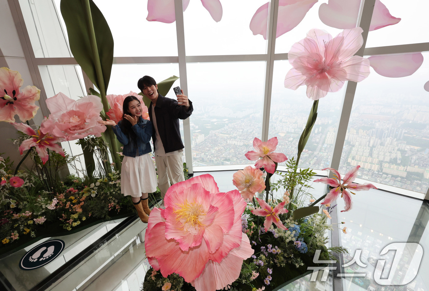 (서울=뉴스1) 박지혜 기자 = 20일 서울 송파구 롯데월드타워 전망대 서울스카이에 마련된 플라워 체험형 공간인 '블루밍 유니버스: 빅플라워' 앞에서 모델들이 포즈를 취하고 있다. …