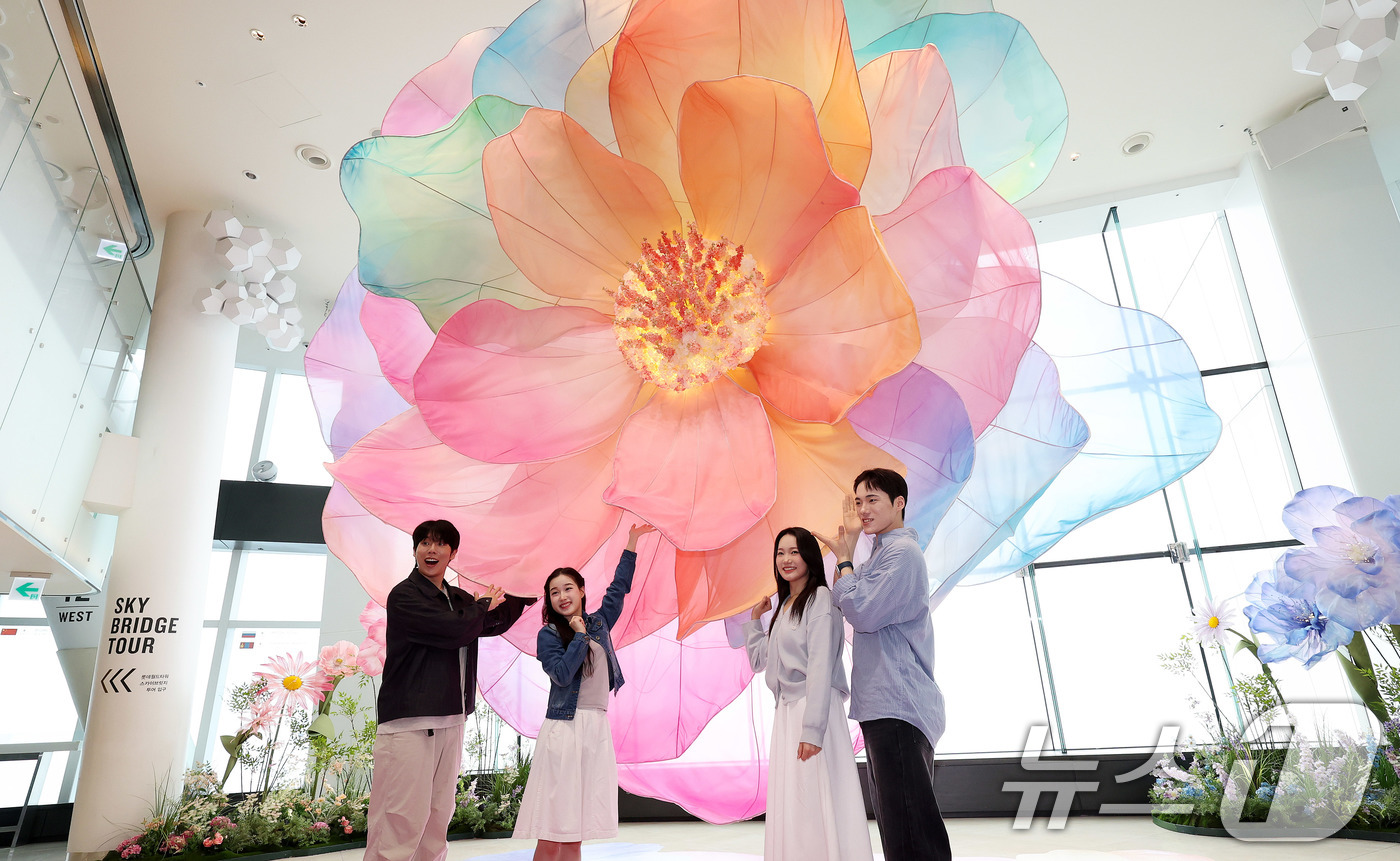 (서울=뉴스1) 박지혜 기자 = 20일 서울 송파구 롯데월드타워 전망대 서울스카이에 마련된 플라워 체험형 공간인 '블루밍 유니버스: 빅플라워' 앞에서 모델들이 포즈를 취하고 있다. …