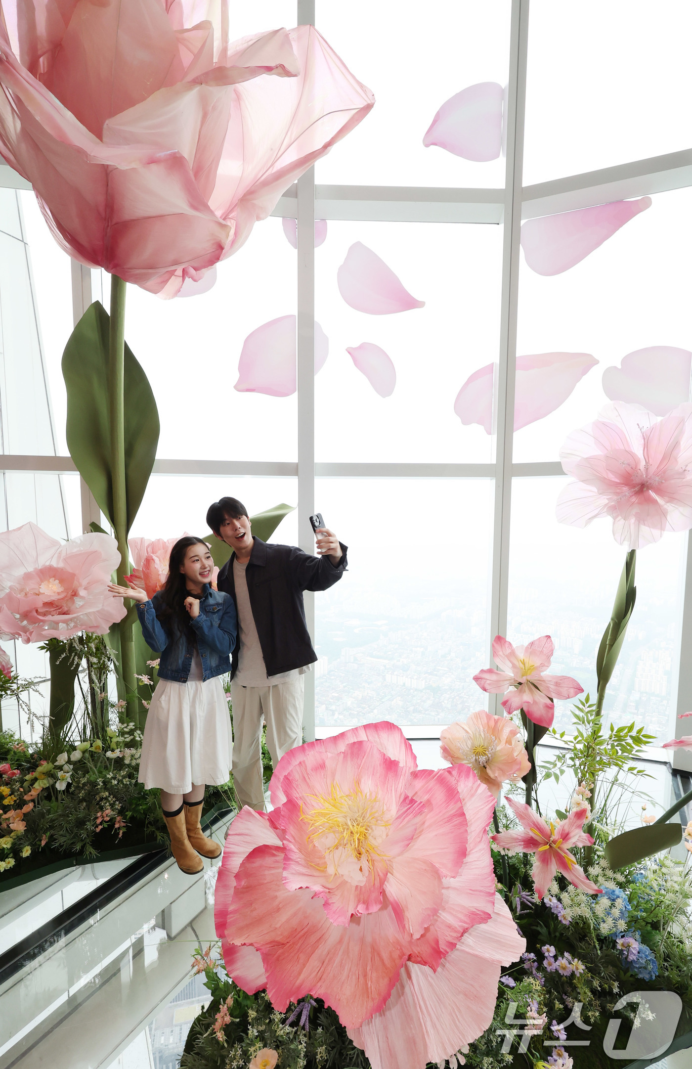 (서울=뉴스1) 박지혜 기자 = 20일 서울 송파구 롯데월드타워 전망대 서울스카이에 마련된 플라워 체험형 공간인 '블루밍 유니버스: 빅플라워' 앞에서 모델들이 포즈를 취하고 있다. …