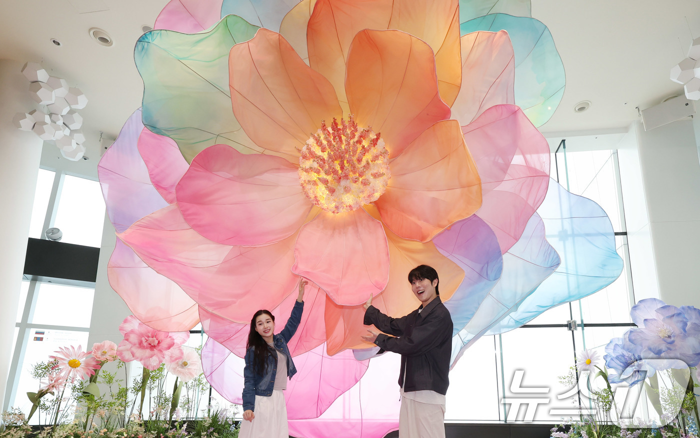 (서울=뉴스1) 박지혜 기자 = 20일 서울 송파구 롯데월드타워 전망대 서울스카이에 마련된 플라워 체험형 공간인 '블루밍 유니버스: 빅플라워' 앞에서 모델들이 포즈를 취하고 있다. …