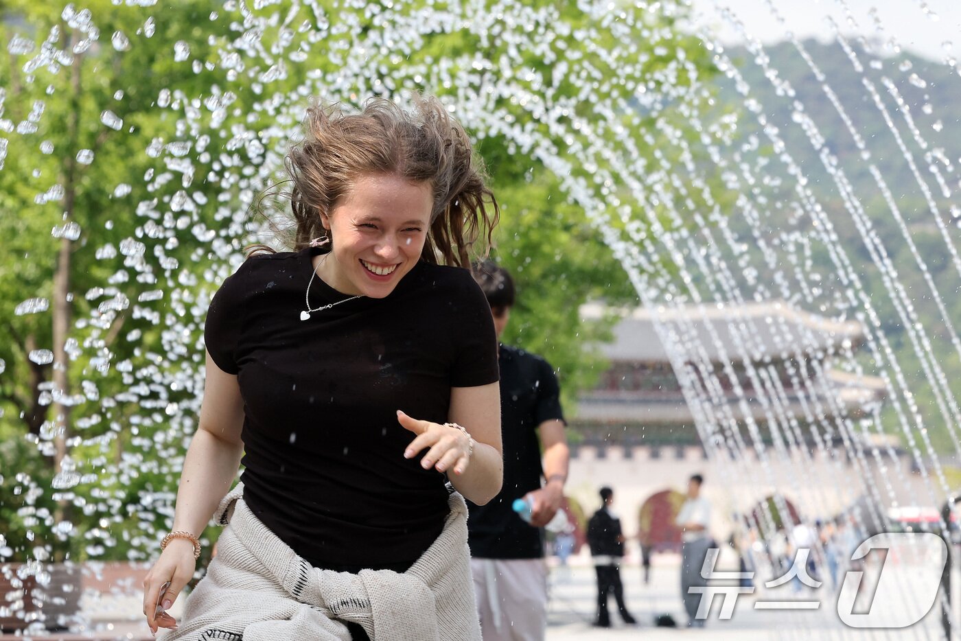 본문 이미지 - 전국 대부분 지역 낮 기온이 25도 이상으로 올라 초여름 날씨를 보인 20일 서울 종로구 광화문광장 분수터널에서 외국인 관광객들이 더위를 식히고 있다. 2025.5.20/뉴스1 ⓒ News1 이동해 기자