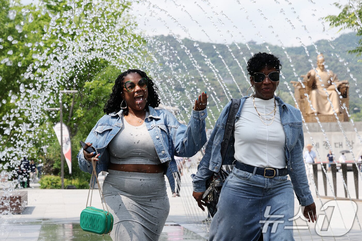 본문 이미지 - 전국 대부분 지역 낮 기온이 25도 이상으로 올라 초여름 날씨를 보인 20일 서울 종로구 광화문광장 분수터널에서 외국인 관광객들이 더위를 식히고 있다. 2025.5.20/뉴스1 ⓒ News1 이동해 기자