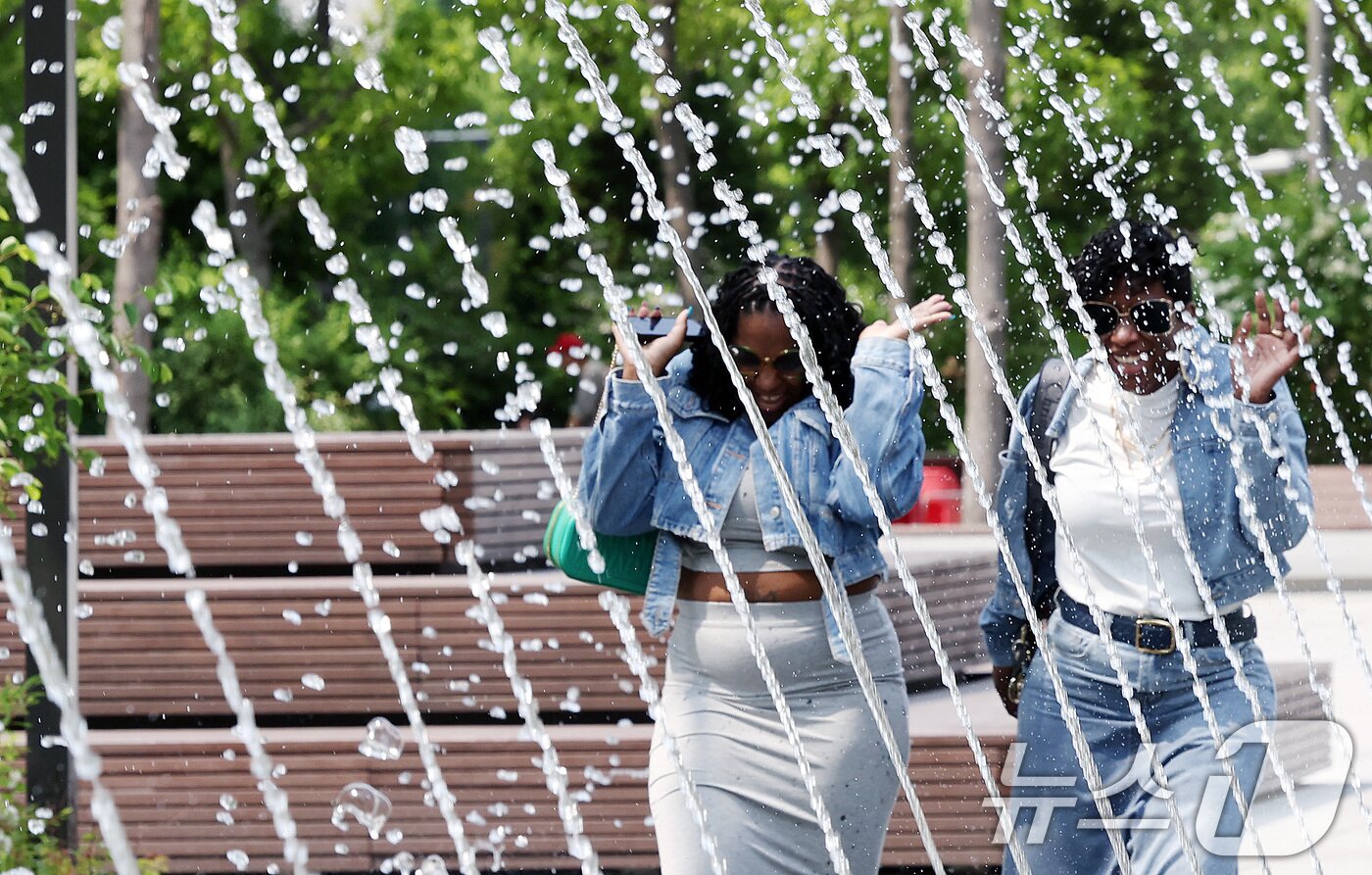 본문 이미지 - 전국 대부분 지역 낮 기온이 25도 이상으로 올라 초여름 날씨를 보인 20일 서울 종로구 광화문광장 분수터널에서 외국인 관광객들이 더위를 식히고 있다. 2025.5.20/뉴스1 ⓒ News1 이동해 기자