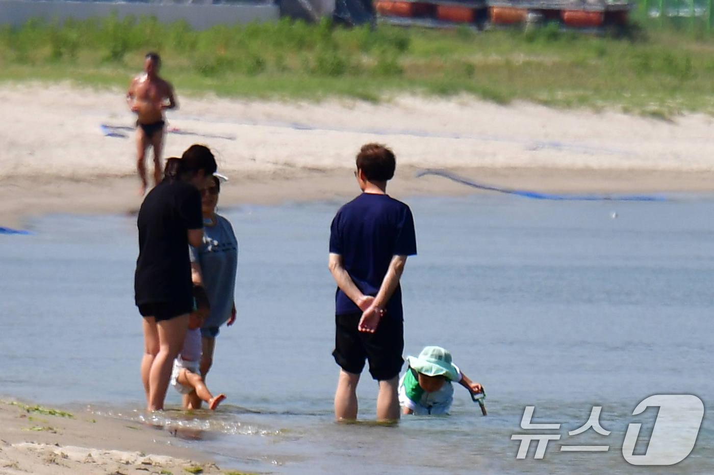 (포항=뉴스1) 최창호 기자 = 경북 포항시의 낮 최고 기온이 33도까지 올라간 20일 오후 송도해수욕장을 찾은 한 가족이 어린 자녀와 함께 바닷물에 발을 담그고 있다.  2025 …