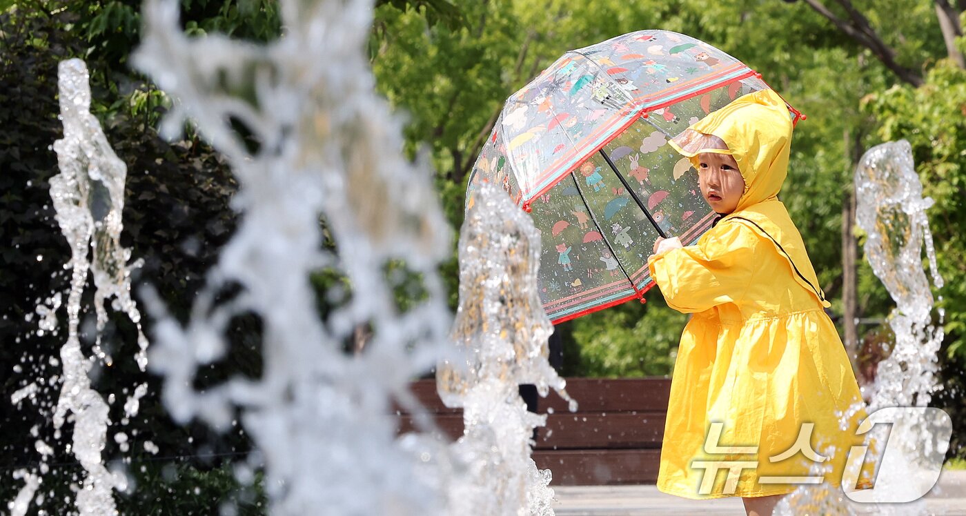 본문 이미지 - 전국 대부분 지역 낮 기온이 25도 이상으로 올라 초여름 날씨를 보인 20일 서울 종로구 광화문광장 바닥분수에서 우의를 입은 한 어린이가 물놀이를 하며 더위를 식히고 있다. 2025.5.20/뉴스1 ⓒ News1 이동해 기자