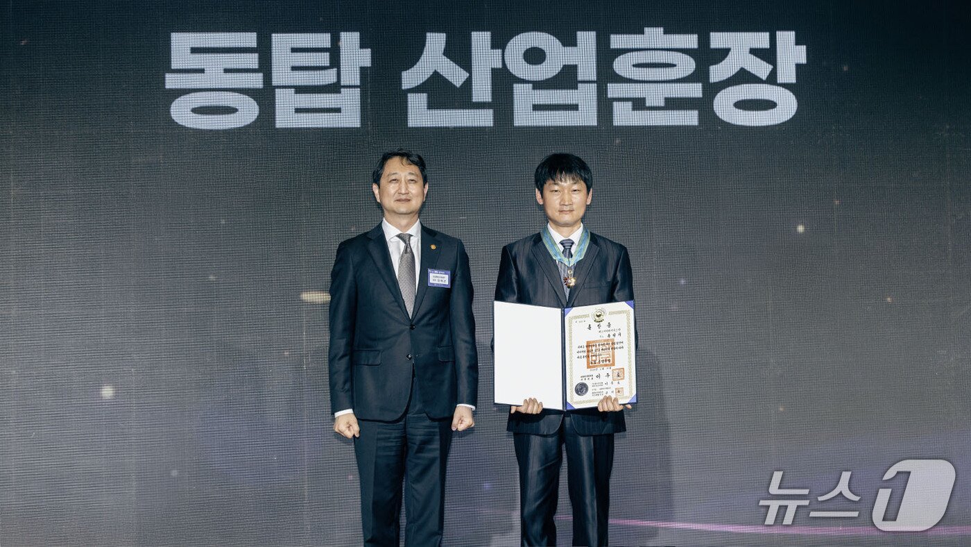 본문 이미지 - 송청기 SK하이닉스 TL이 19일 제60회 발명의 날 기념식에서 동탑산업훈장을 받은 후 안덕근 산업통상자원부 장관과 기념 촬영하고 있다.(SK하이닉스 뉴스룸)