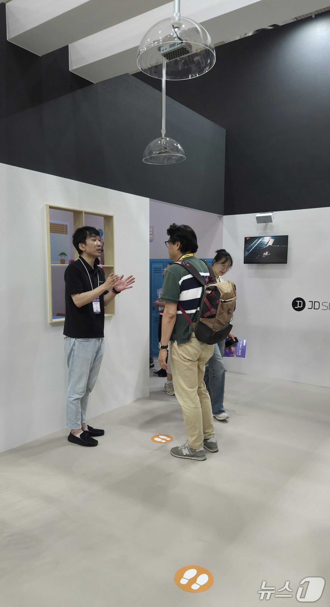 본문 이미지 - 제이디솔루션 초지향성 스피커 '브릭미니'가 천장에 설치돼 있다. 바닥에 표시된 발자국에 올라 서면 소리가 들린다. 2025.5.20/ⓒ뉴스1 이정후 기자