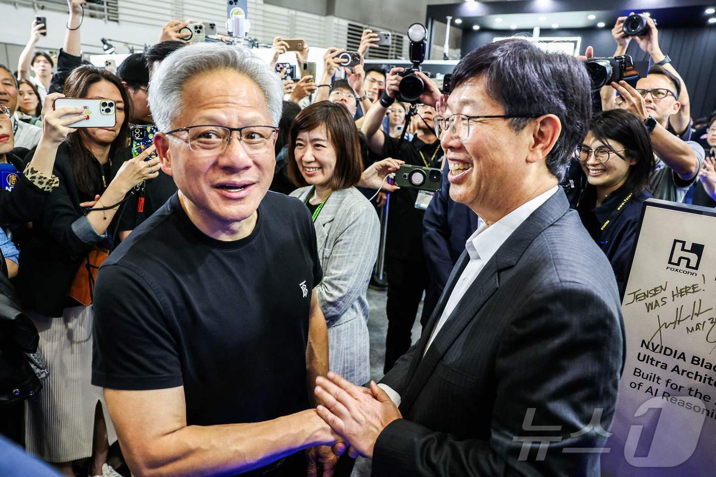 본문 이미지 - 젠슨 황 엔비디아 CEO가 20일 &#40;현지시간&#41; 타이베이 난강 전시관에서 열린 &#39;컴퓨텍스 2025&#39;에 도착해 류양웨이 폭스콘 회장과 악수를 하고 있다. 2025.05.21 ⓒ AFP=뉴스1 ⓒ News1 우동명 기자