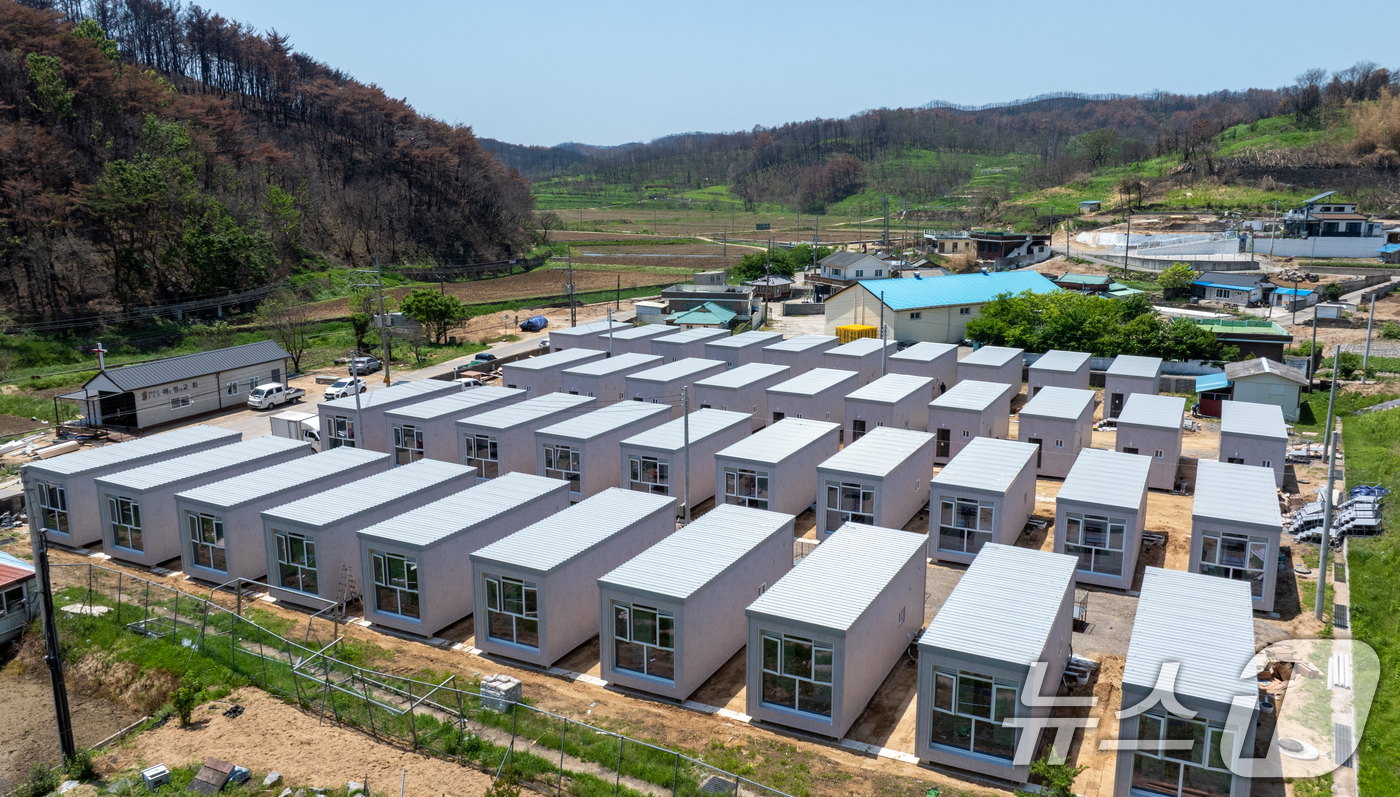 (영덕=뉴스1) 최창호 기자 = 초대형산불피해지역인 21일 경북 영덕군 영덕읍 매정리 초등학교 앞 부지에 경북도가 지원한 모듈러 주택 40동이 설치되고 있다. 2025.5.21/뉴 …