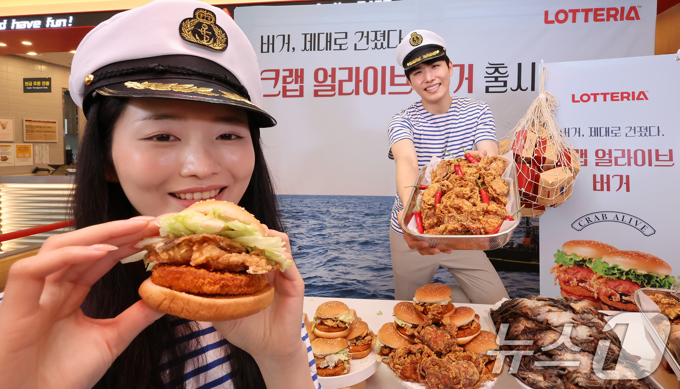 (서울=뉴스1) 장수영 기자 = 21일 서울 롯데리아 동대문역사문화공원역점에서 모델들이  '크랩 얼라이브 버거'를 소개하고 있다.롯데리아는 통째로 먹을 수 있는 소프트쉘 게 한 마 …