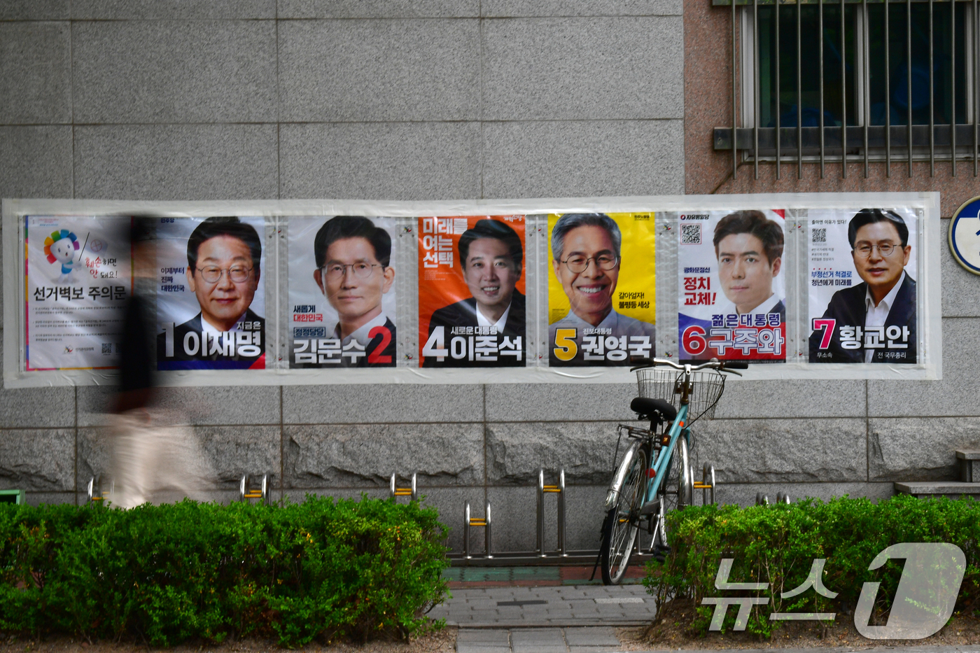 (포항=뉴스1) 최창호 기자 = 2025대통령 선거를 12일 앞둔 22일 오전 츨근길에 나선 시민이 경북 포항시 남구 대잠동 행정복지센터 벽에 붙어 있는 대통령후보 선거 벽보 앞을 …