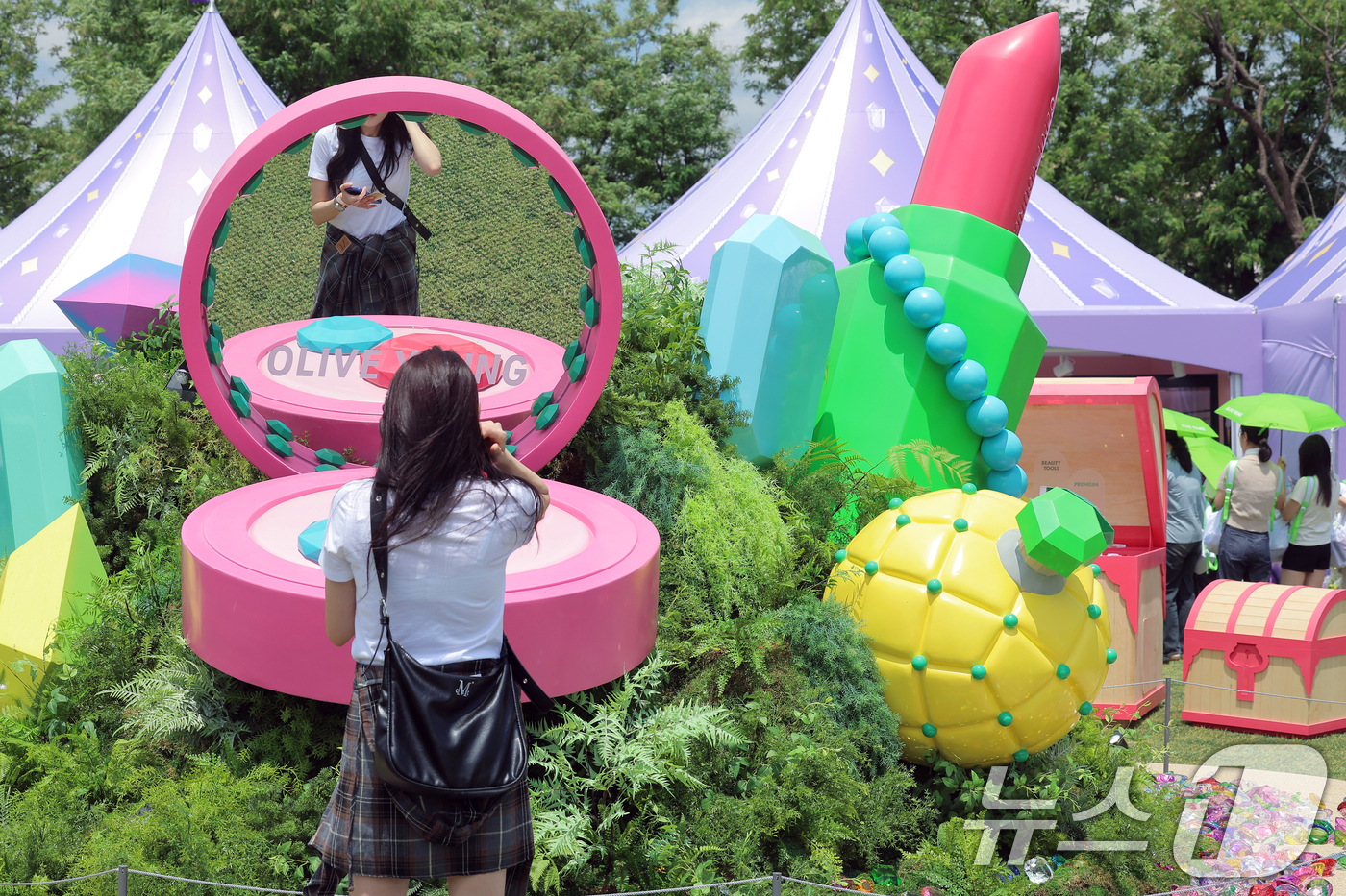 (서울=뉴스1) 박정호 기자 = 22일 서울 노들섬에서 열린 국내 최대 규모 체험형 뷰티&헬스 축제 '2025 올리브영 페스타'를 찾은 방문객이 대형 쿠션의 거울을 통해 아름다움을 …