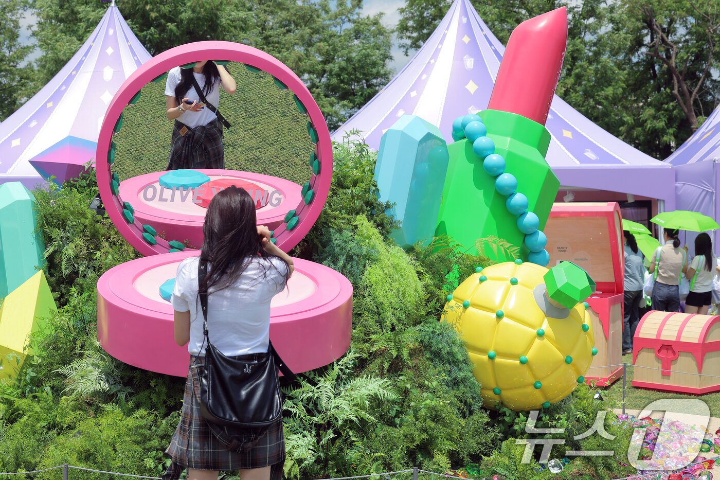 본문 이미지 - 22일 서울 노들섬에서 열린 국내 최대 규모 체험형 뷰티&헬스 축제 &#39;2025 올리브영 페스타&#39;를 찾은 방문객이 대형 쿠션의 거울을 통해 아름다움을 점검하고 있다.2025.5.22/뉴스1 ⓒ News1 박정호 기자