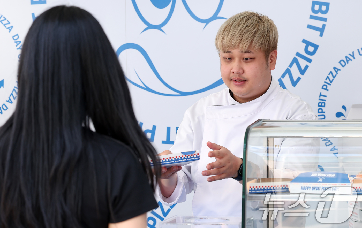 (서울=뉴스1) 김성진 기자 = 윤남노 셰프가 22일 서울 광진구 건국대학교에서 열린 '업비트 피자데이-캠퍼스 피자어택' 행사에서 학생들에게 비트피자를 건네고 있다.'비트코인 피자 …