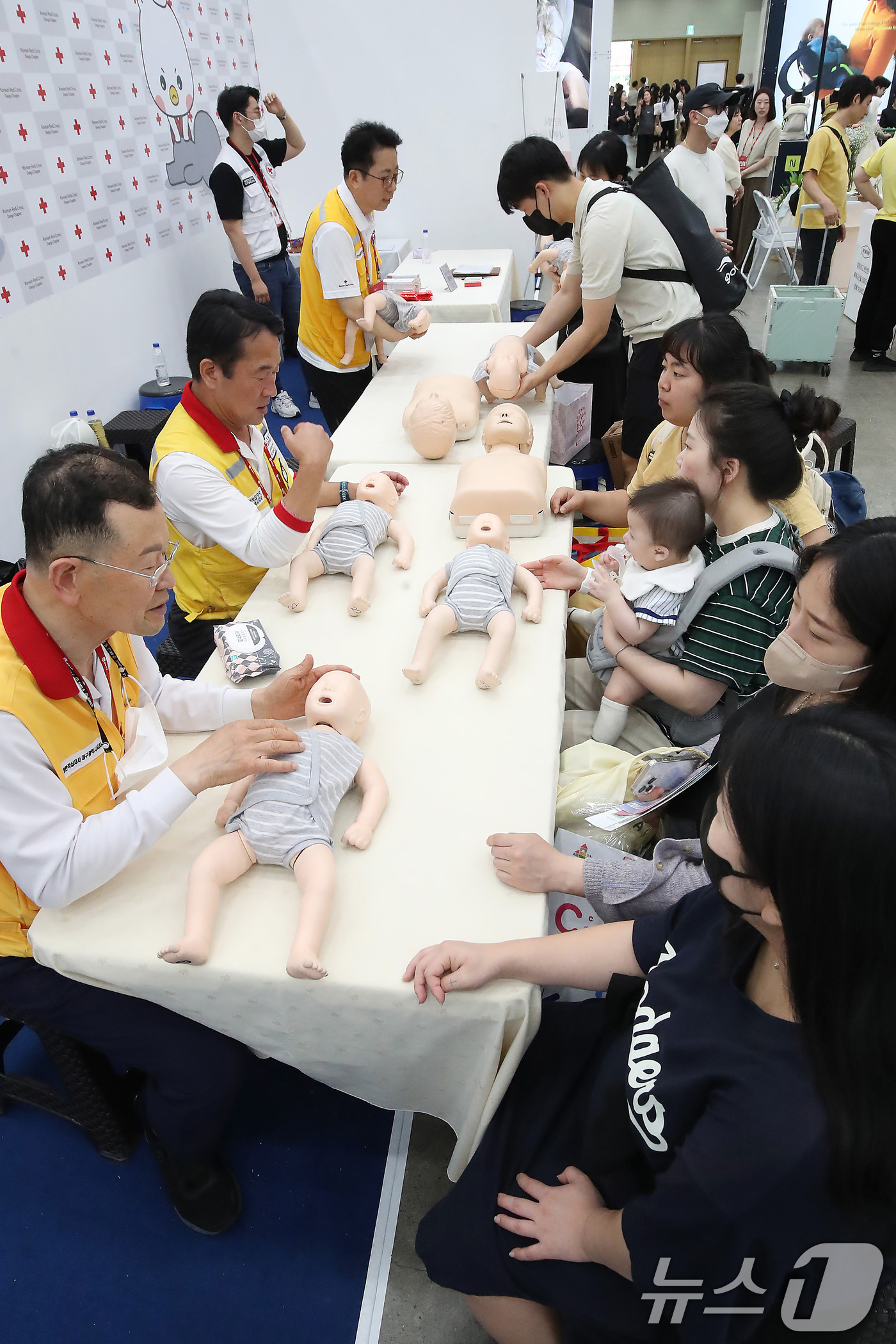 (대구=뉴스1) 공정식 기자 = 22일 대구 북구 엑스코(EXCO)에서 개막한 '2025 대구 베이비&키즈페어'를 찾은 부모들이 대한적십자사 대구지사 부스에서 영유아 응급처치법을 …