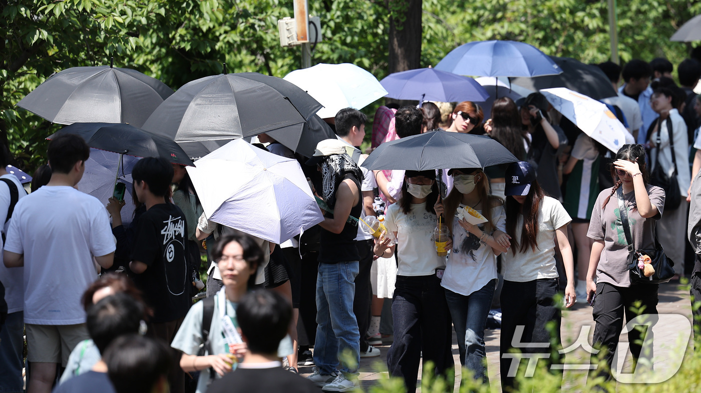 (서울=뉴스1) 김성진 기자 = 전국적으로 초여름 날씨를 보인 22일 서울 광진구 건국대학교에서 학생들이 우산과 양산으로 햇빛을 가린 채 노천극장 입장을 기다리고 있다. 2025. …