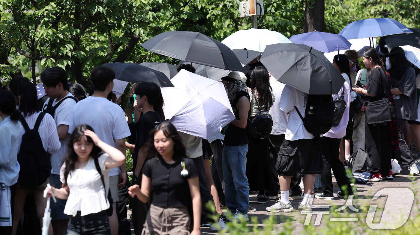 (서울=뉴스1) 김성진 기자 = 전국적으로 초여름 날씨를 보인 22일 서울 시내 한 대학교에서 학생들이 우산과 양산으로 햇빛을 가린 채 노천극장 입장을 기다리고 있다. 2025.5 …