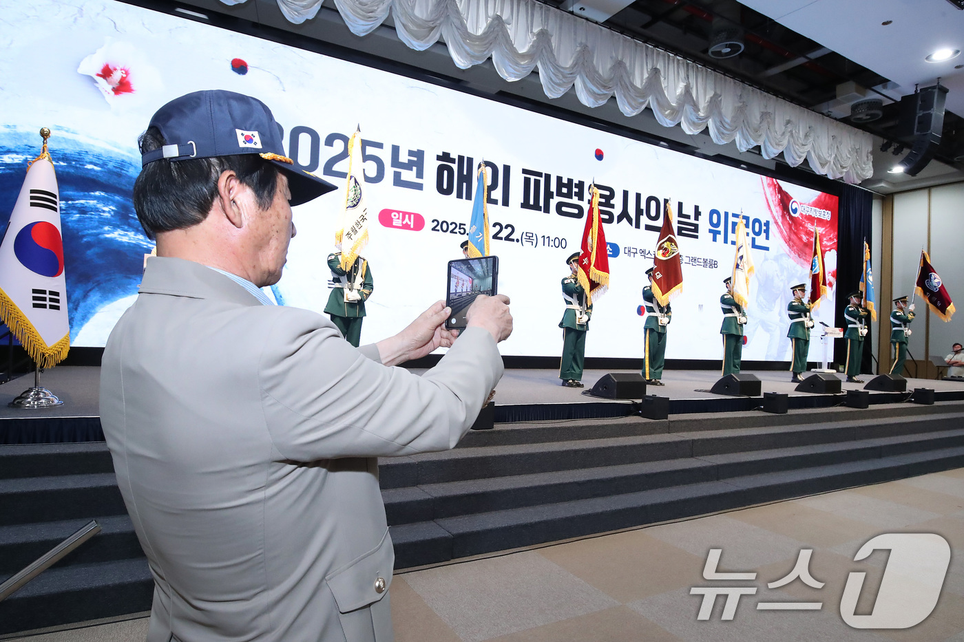 (대구=뉴스1) 공정식 기자 = 22일 대구 북구 엑스코(EXCO)에서 열린 '해외 파병용사의 날 위로연'에 참석한 노병이 참전 부대기 입장을 묵묵히 촬영하고 있다.대구지방보훈청 …