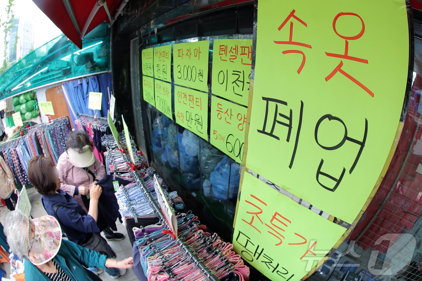 본문 이미지 - 올해 문을 닫는 자영업자 수가 100만을 넘을 것이란 전망이 나온 23일 서울 서대문구 홍제동의 &#39;속옷 폐업&#39;을 붙인 가게에서 주민 등이 물건을 고르고 있다. ⓒ News1 박정호 기자