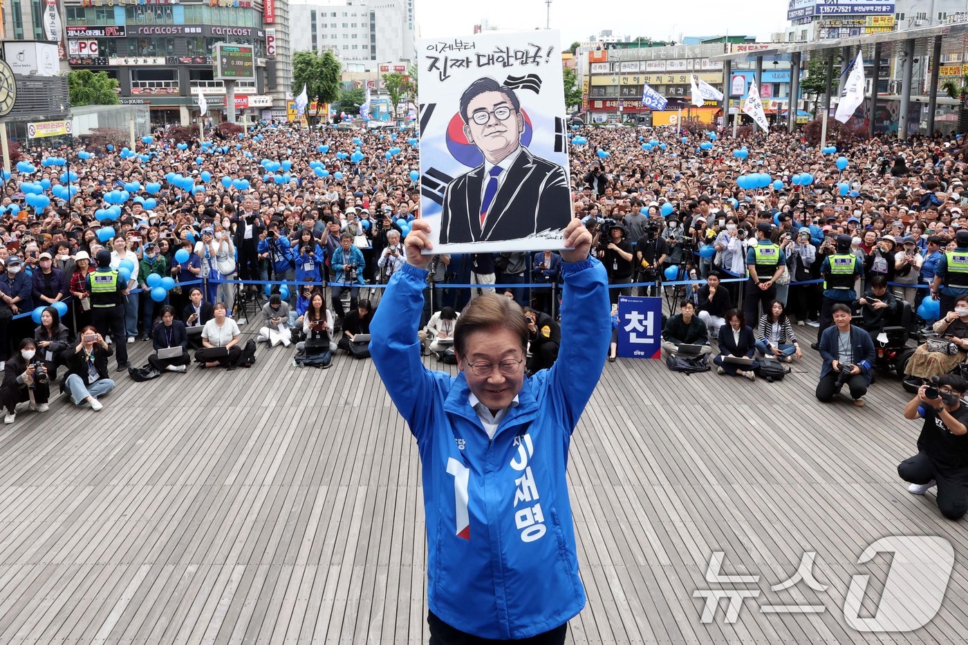 (부천=뉴스1) 이재명 기자 = 이재명 더불어민주당 대통령 후보가 24일 오후 경기도 부천시 부천역 북부광장에서 열린 유세에서 자신의 캐리커처 그림을 들어 보이고 있다. (공동취재 …