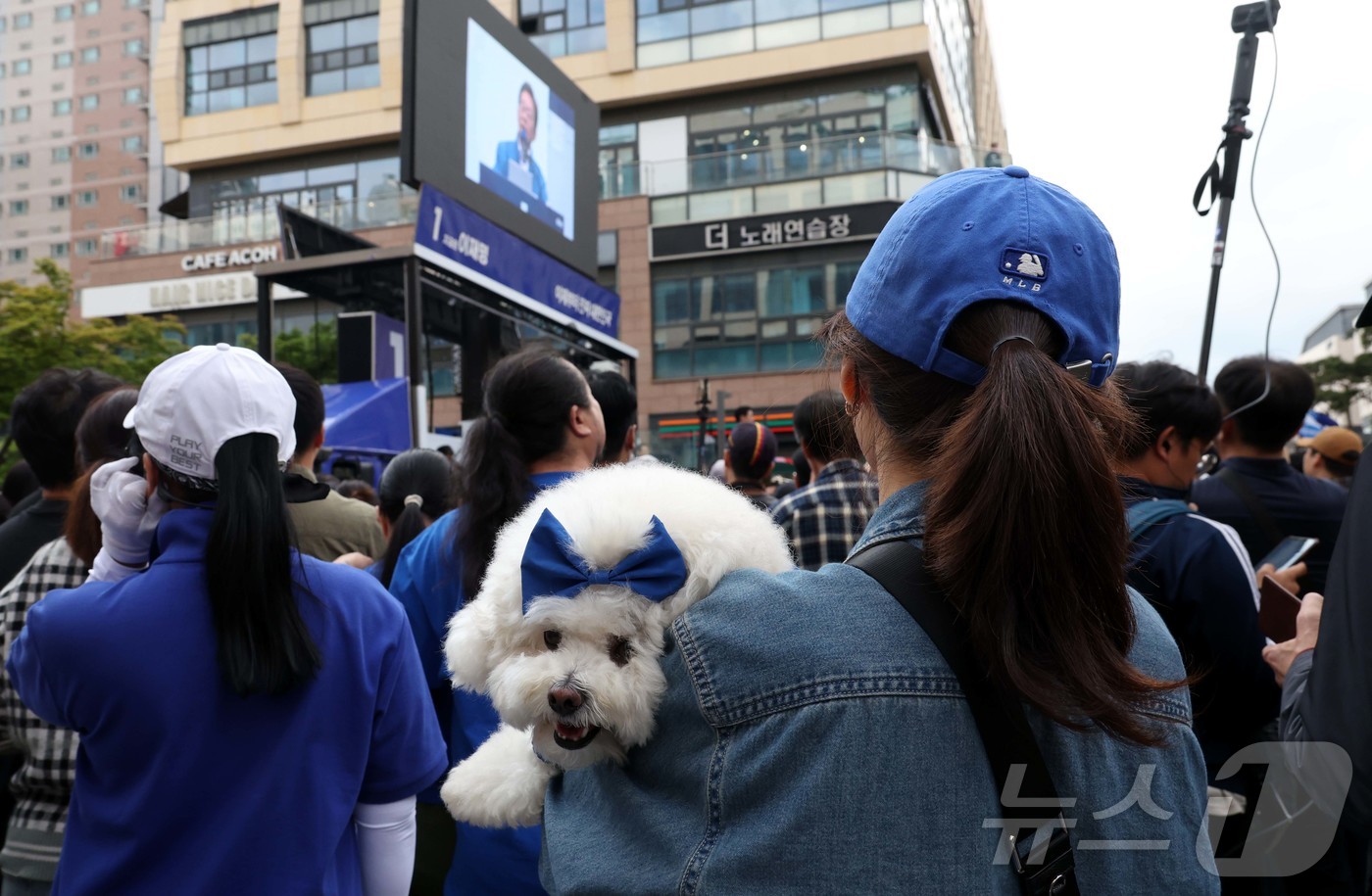(시흥=뉴스1) 이재명 기자 = 24일 경기 시흥 배곧아브뉴프랑 센트럴광장에서 열린 유세에서 한 시민이 강아지를 안고 이재명 더불어민주당 대선후보의 유세를 지켜보고 있다.(공동취재 …