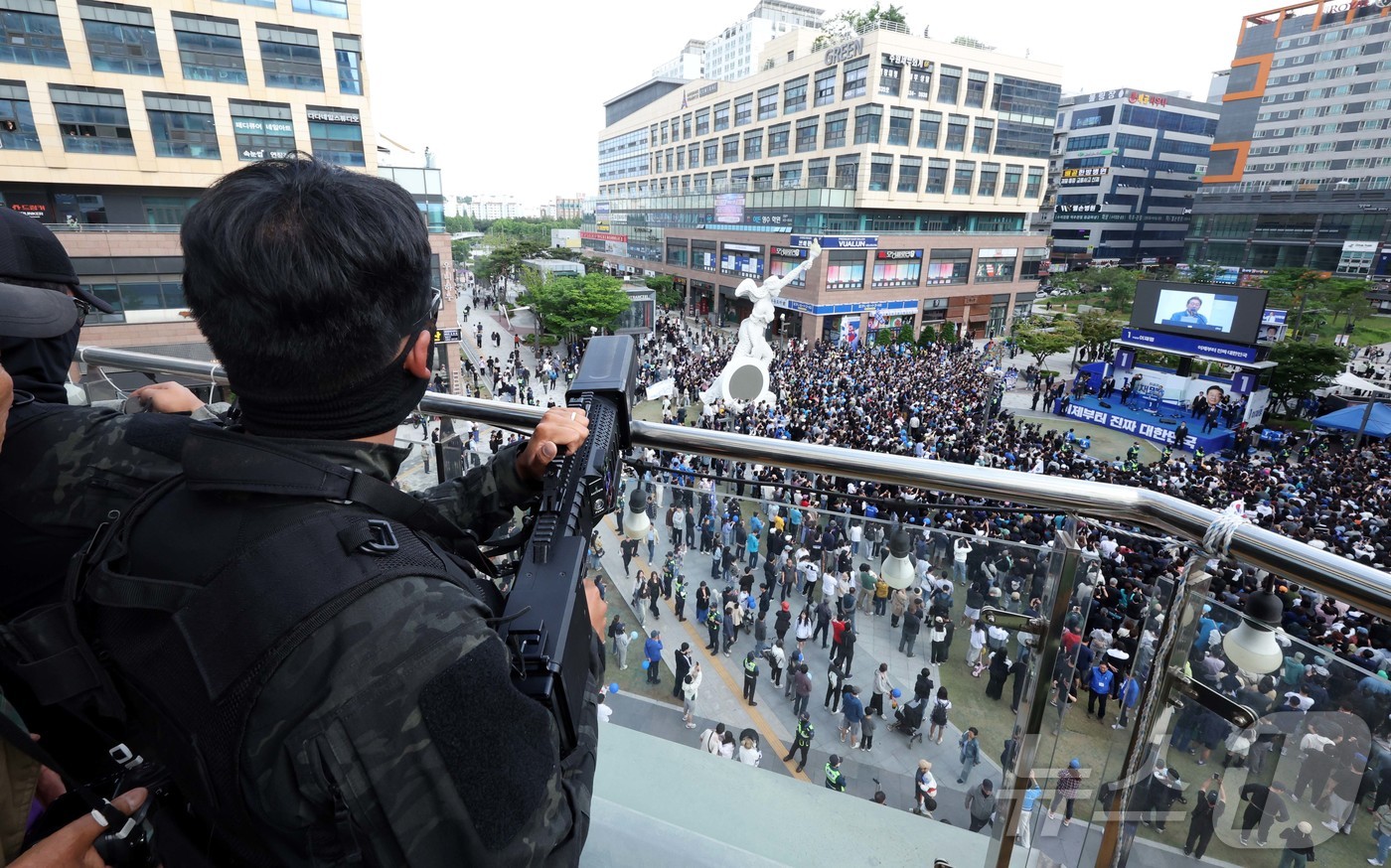 (시흥=뉴스1) 이재명 기자 = 이재명 더불어민주당 대선 후보가 24일 경기 시흥 배곧아브뉴프랑 센트럴광장에서 유세를 하고 있는 가운데 드론재밍건을 든 경찰특공대가 경계근무를 서고 …