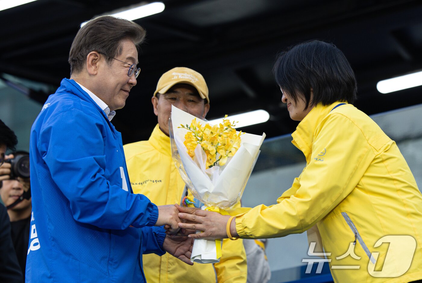 본문 이미지 - 이재명 더불어민주당 대통령 후보가 24일 오후 경기도 안산시 단원구 안산문화광장에서 세월호 참사 유족에게 프리지아 꽃을 전달 받고 있다. 2025.5.24/뉴스1 ⓒ News1 이재명 기자