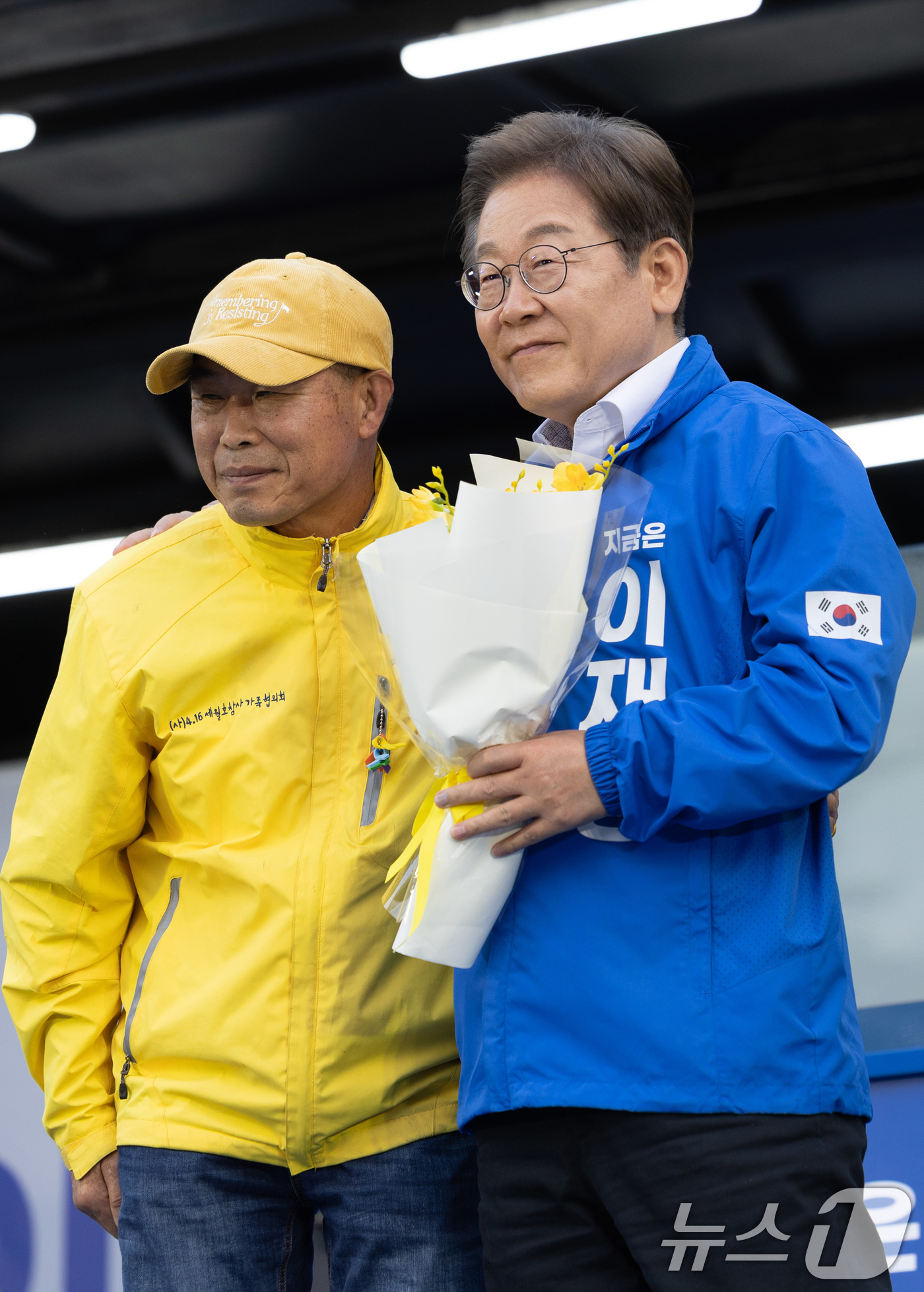 (안산=뉴스1) 이재명 기자 = 이재명 더불어민주당 대통령 후보가 24일 오후 경기도 안산시 단원구 안산문화광장에서 세월호 참사 유족에게 프리지아 꽃을 전달 받은 후 위로하고 있다 …