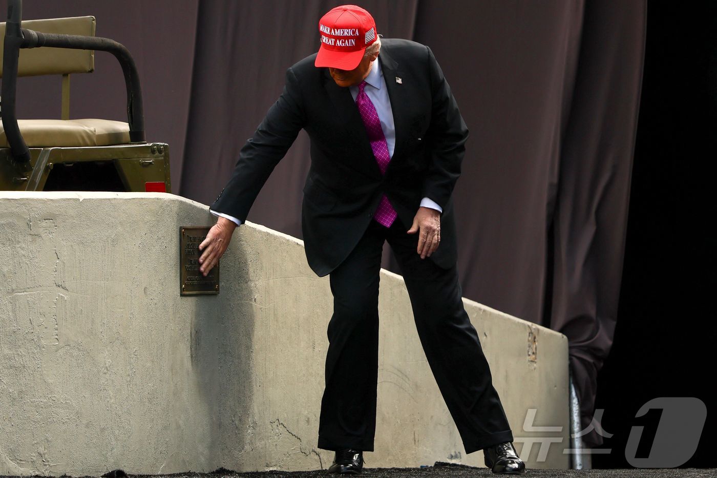 (뉴욕 AFP=뉴스1) 우동명 기자 = 도널드 트럼프 미국 대통령이 24일(현지시간) 뉴욕에 있는 웨스트포인트 육군사관학교 졸업식에 참석해 명판을 만지고 있다. 2025.5.25ⓒ …