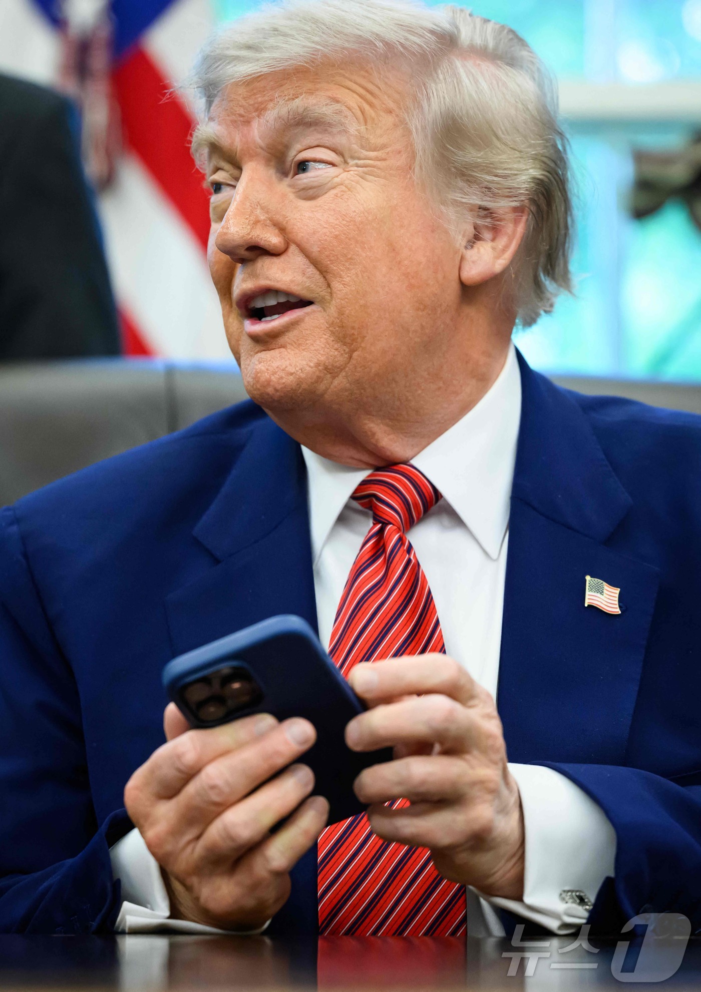 (워싱턴 AFP=뉴스1) 우동명 기자 = 도널드 트럼프 미국 대통령이 23일(현지시간) 워싱턴 백악관에서 행정 명령에 서명을 하면서 취재진과 만나는 중 아이폰 벨 소리가 울리자 ‘ …