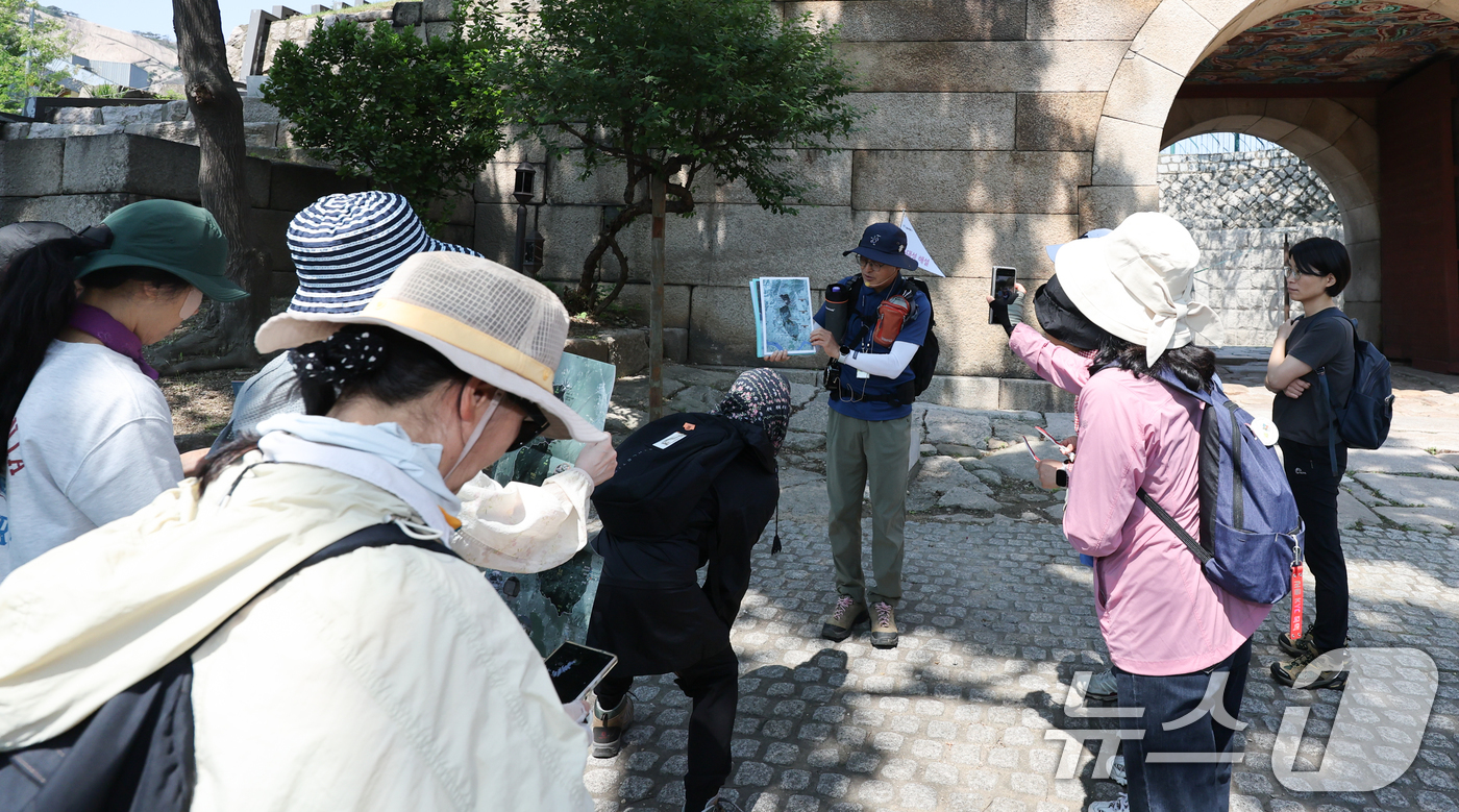 (서울=뉴스1) 허경 기자 = 서울시 관계자가 25일 서울 종로구 창의문에서 시작해 성불사, 탕춘대성, 홍지문으로 이어지는 해설 프로그램 출발에 앞서 코스를 설명하고 있다.서울시는 …